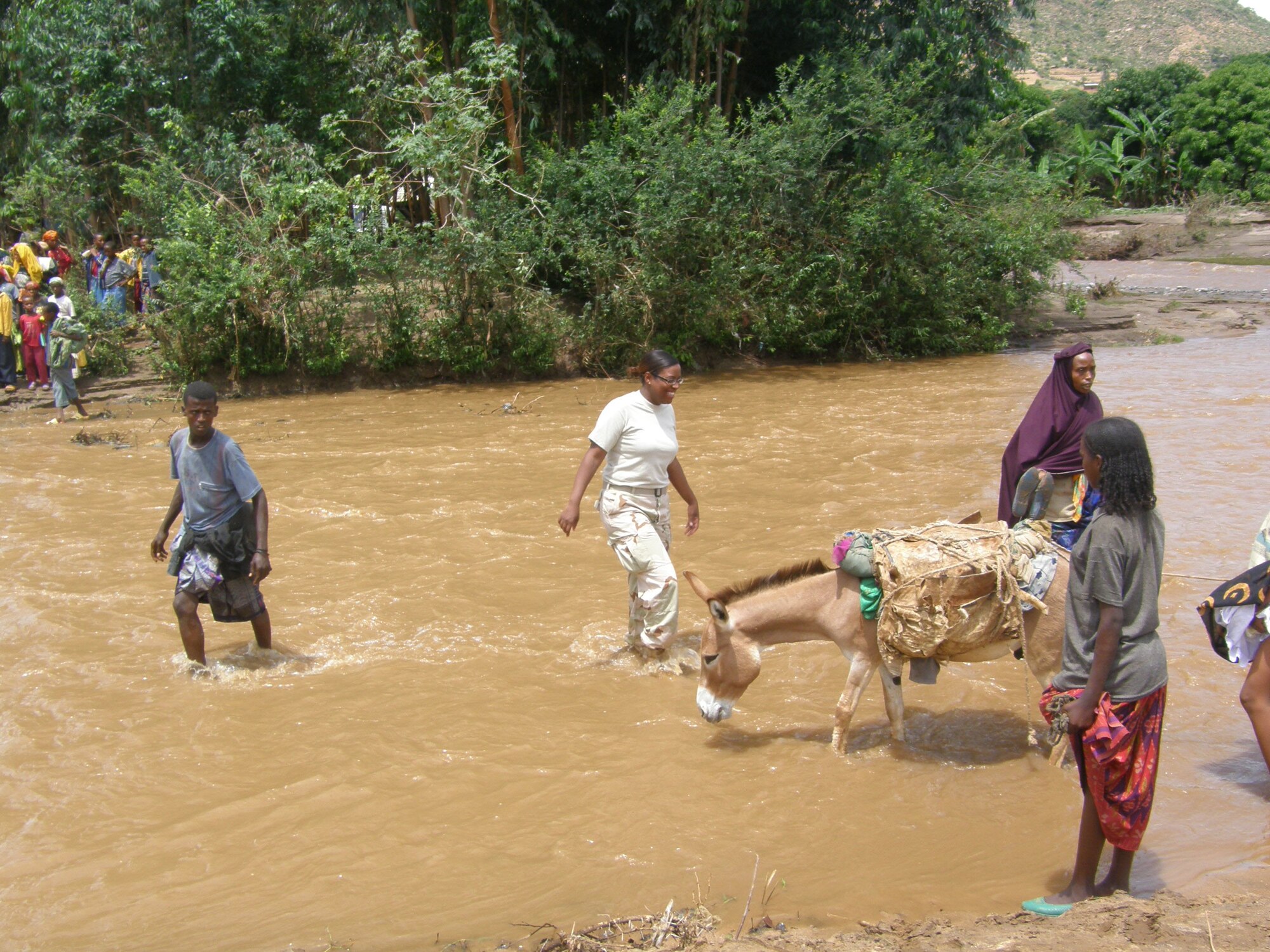 SEYMOUR JOHNSON AIR FORCE BASE, N.C. -- Staff Sgt. Veronica Jefferson (center), a Reservist with the 916th Communications Squadron, walks across a small river in Ethiopia after helping other motorists that were stuck in the mud. Sgt. Jefferson is deployed to Djibouti, but was helping provide radio communications during a veterinarian mission to Ethiopia.