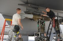 MINOT AIR FORCE BASE, N.D. -- Tech. Sgt. Jamie  Mikus and Staff Sgt. Troy Becker, weapons loaders from the 5th Aircraft Maintenance Squadron, load a GBU-38 bomb onto a B-52H Stratofortress during a weapons loading competition here June 30. Each load crew team consists of four Airmen who are evaluated every month on how well they load different types of weapons. (U.S. Air Force photo by Senior Airman Cassandra Jones)