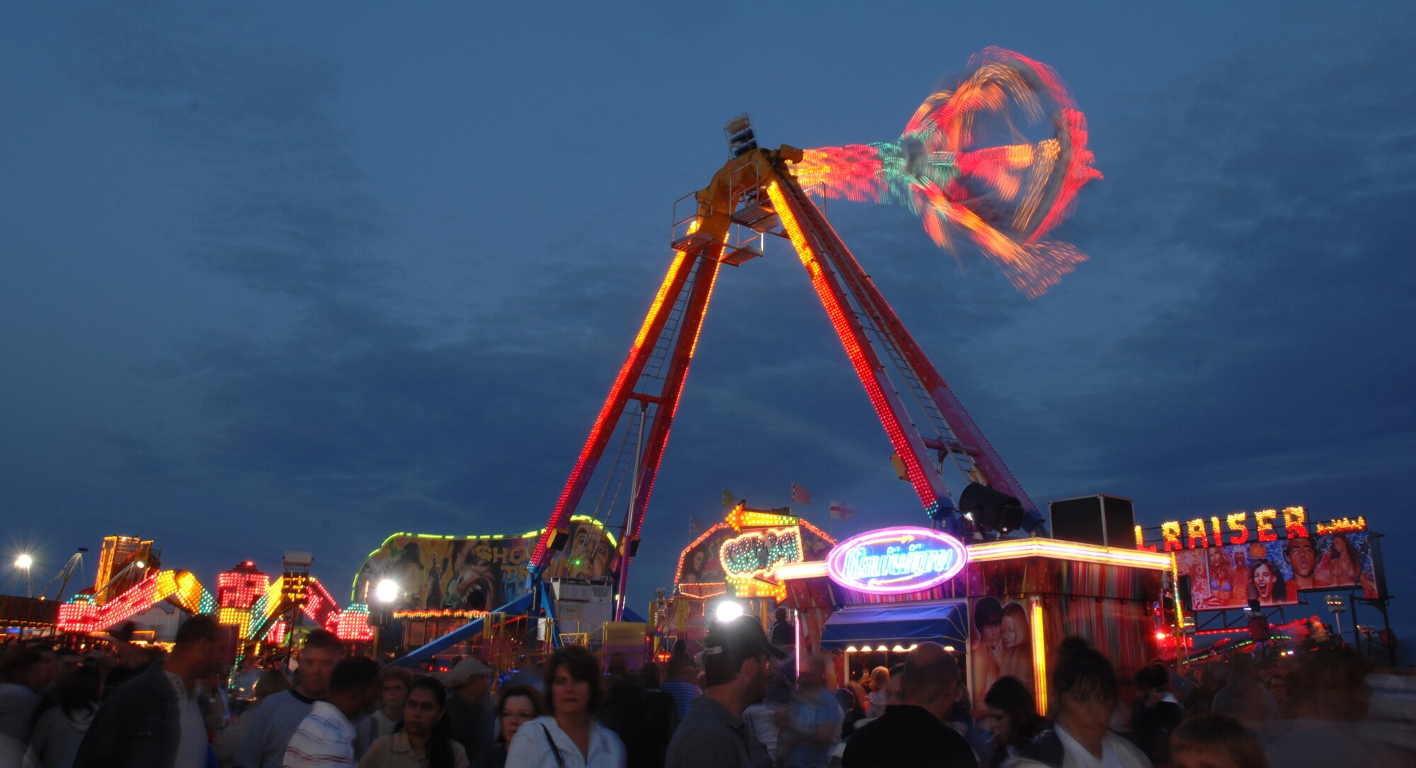 RAF FELTWELL, England -- While waiting for a traditional American fireworks display to begin, a crowd of almost 15,000 people from RAFs Feltwell, Lakenheath, and Mildenhall as well as the local British community, partake in carnival festivities, including rides, games, and food and drink booths. All the festivities were included as part of the RAF Feltwell Fourth of July celebration. The patriotic event hosted at RAF Feltwell each year usually draws a large crowd, and this year held up to that standard with partly cloudy weather as a backdrop. (U.S. Air Force photo by Master Sgt. Tracy L. DeMarco)