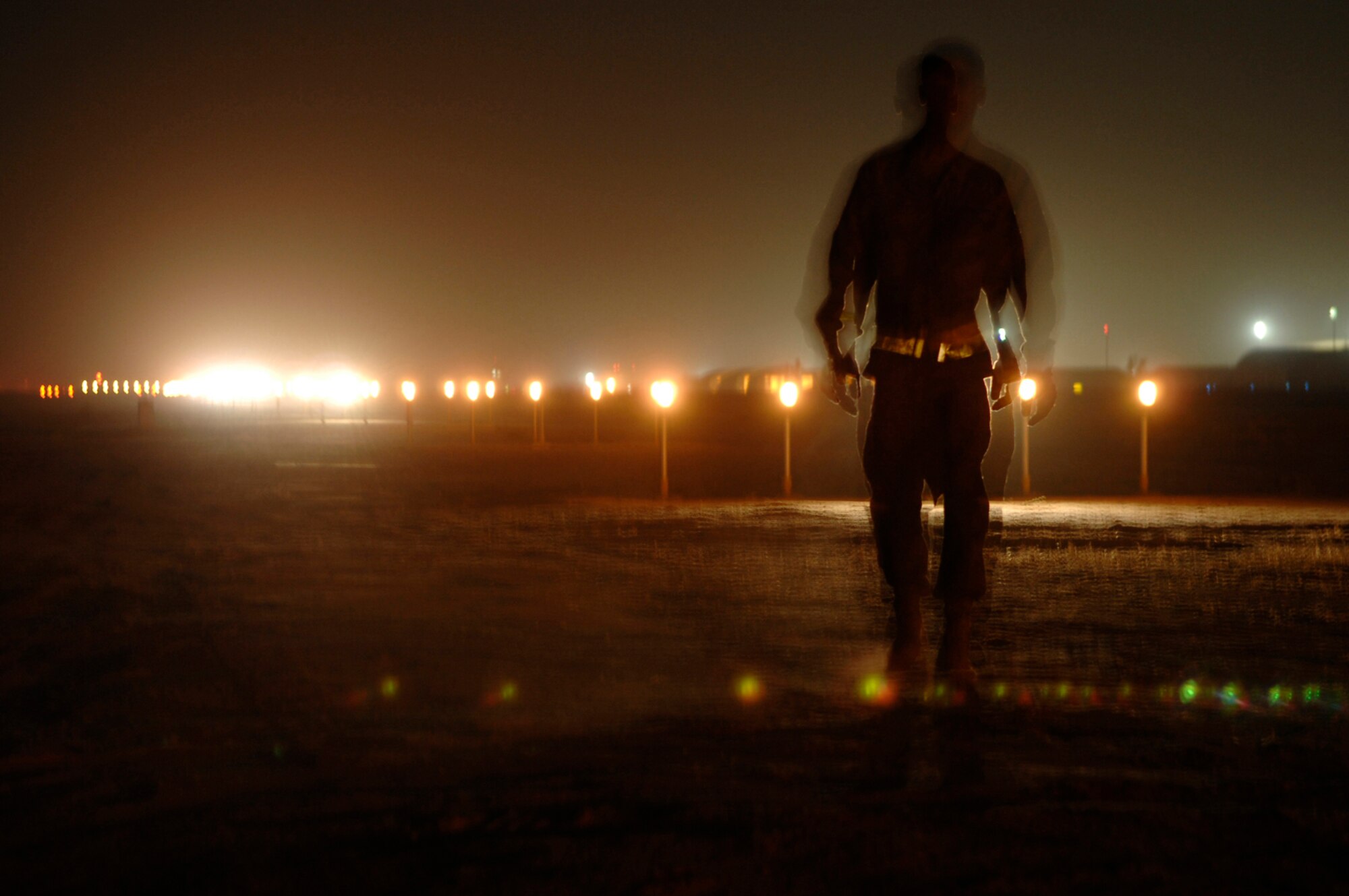 JOINT BASE BALAD, Iraq -- Staff Sgt. Samnang Lay, 332nd Expeditionary Civil Engineer Squadron electrician, walks down the line of approach lights to ensure the strobes are operational here, July 5. Sergeant Lay is deployed from Ellsworth Air Force Base, S.D. (U.S. Air Force photo/ Senior Airman Julianne Showalter)