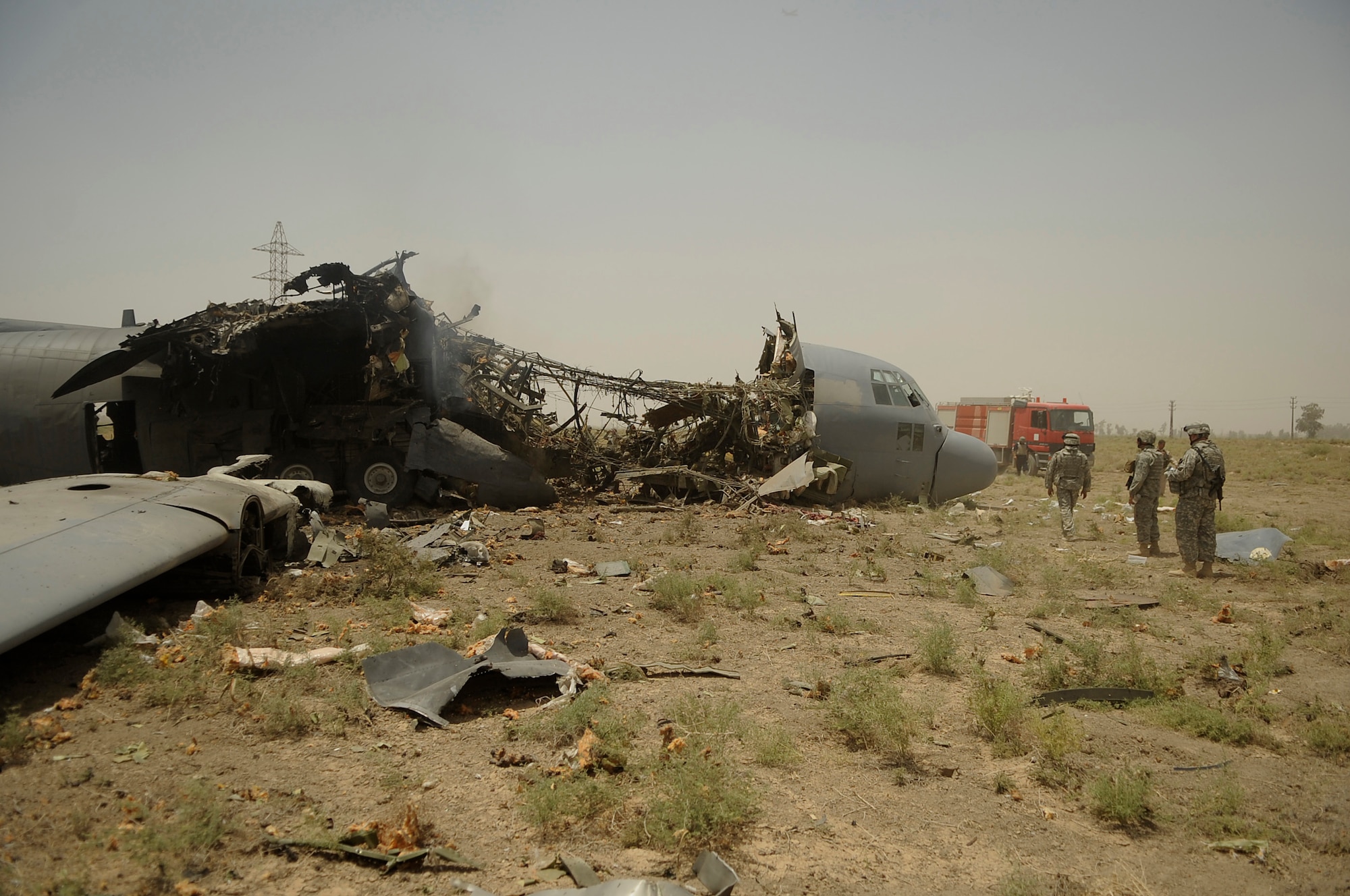 BAGHDAD, Iraq -- Explosive Ordinance Disposal personnel from the 447th Expeditionary Civil Engineer Squadron at Sather Air Base survey their work after using explosives to separate the forward section of a C-130 Hercules here July 7. The EOD team is using a series of controlled detonations designed to divide the airplane into smaller pieces so it can be easily moved. The C-130 made an emergency landing in a field north of  Baghdad International Airport shortly after take-off June 27. (U.S. Air Force photo/Tech. Sgt. Jeffrey Allen)