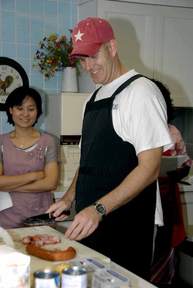 OSAN AIR BASE, Republic of Korea – Capt. Kevin Jernigan, 7th Air Force deputy director of personnel, manpower and resources, cuts kielbasa that will be added to Cajun stew during the Cajun cooking class held July 1 at the Airman and Family Readiness Center. The AFRC hosts several different cooking classes including Southern and Caribbean styles. (U.S. Air Force photo/Staff Sgt Lakisha Croley)