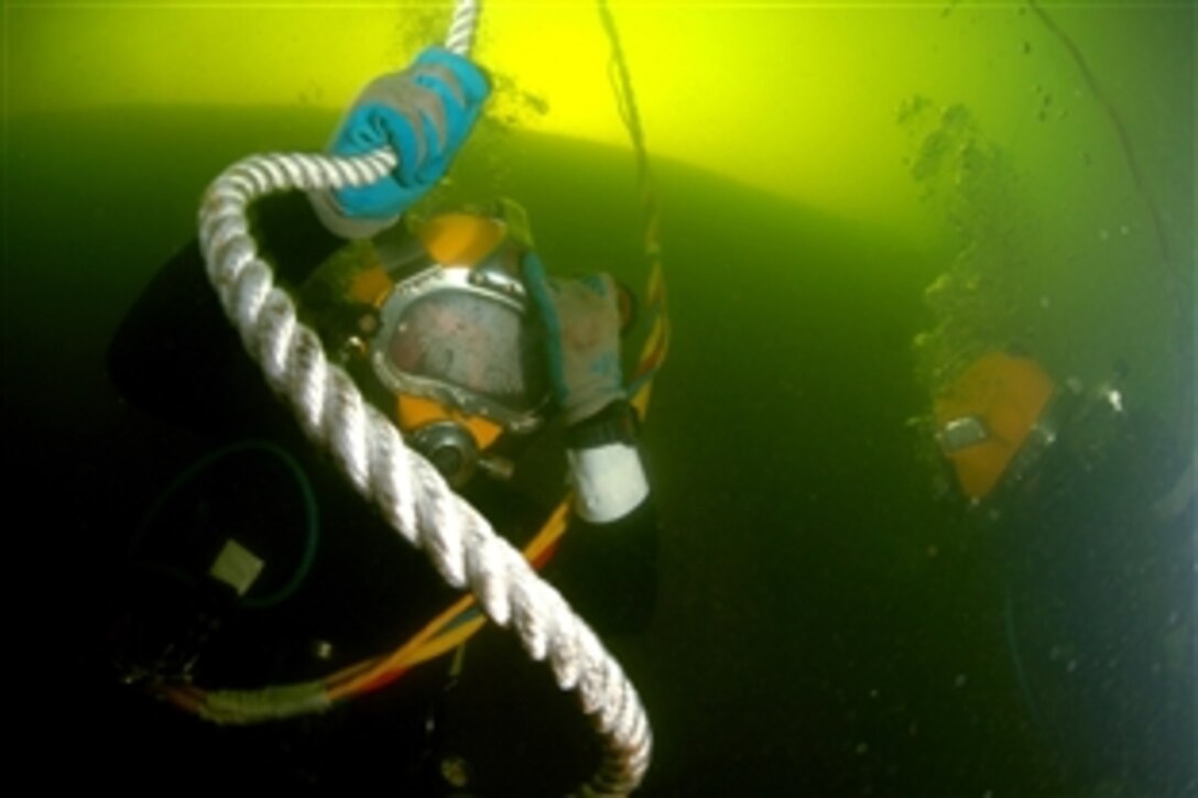 U.S. Army Staff Sgt. Joshua West lowers himself to the sunken former Soviet submarine Juliett 484 to conduct salvage operations, Providence, R.I., July 7, 2008. U.S. Navy and Army divers along with federal, state and local authorities are working to raise the sunken former Soviet submarine at Collier Point Park. Mobile Diving & Salvage Unit 2, U.S. Army Dive Company and a NAVSEA Support Unit prepare to salvage the former Soviet submarine.