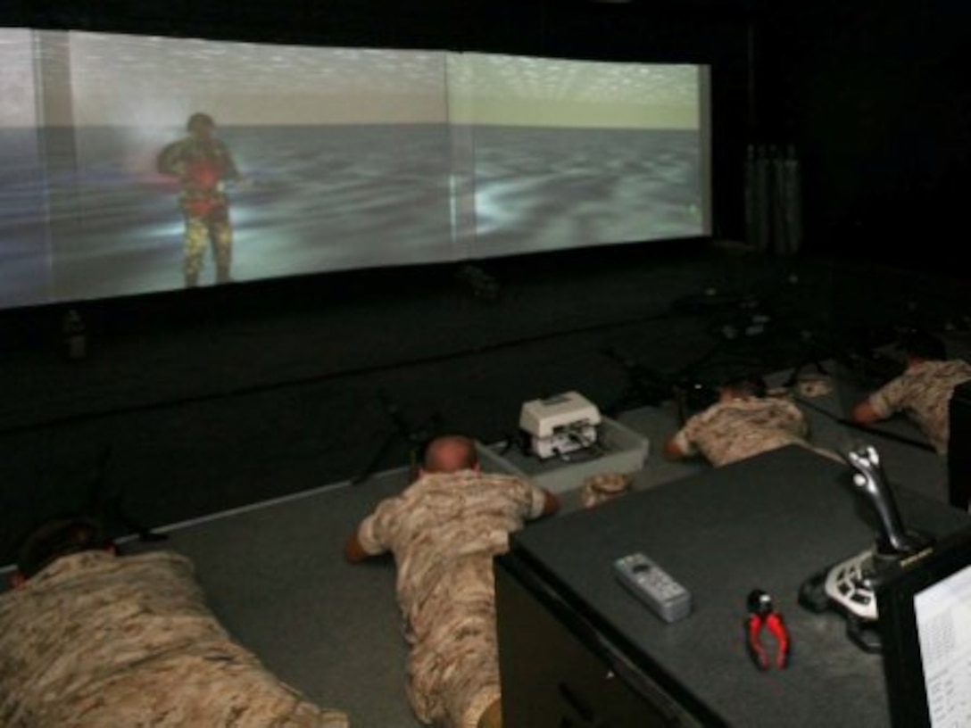 Corporal Shawn M. Seguin, chief instructor at the 2nd Marine Logistics Group Indoor Simulated Marksmanship Trainer, assists Marines from 2nd Anglico Battalion, II Marine Expeditionary Force during training.