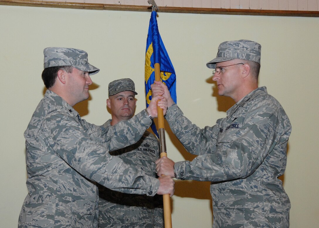 Brig. Gen Doug Owens, 36th Wing commander, presents Col. Daniel Settergen with the 36th Contingency Response Group guidon signifying the change of command July 8 here. Colonel Settergen arrived here from Headquarters Special Operations Center Hurlburt Field, Fla. (U.S. Air Force by Airman 1st Class Nichelle Griffiths) 