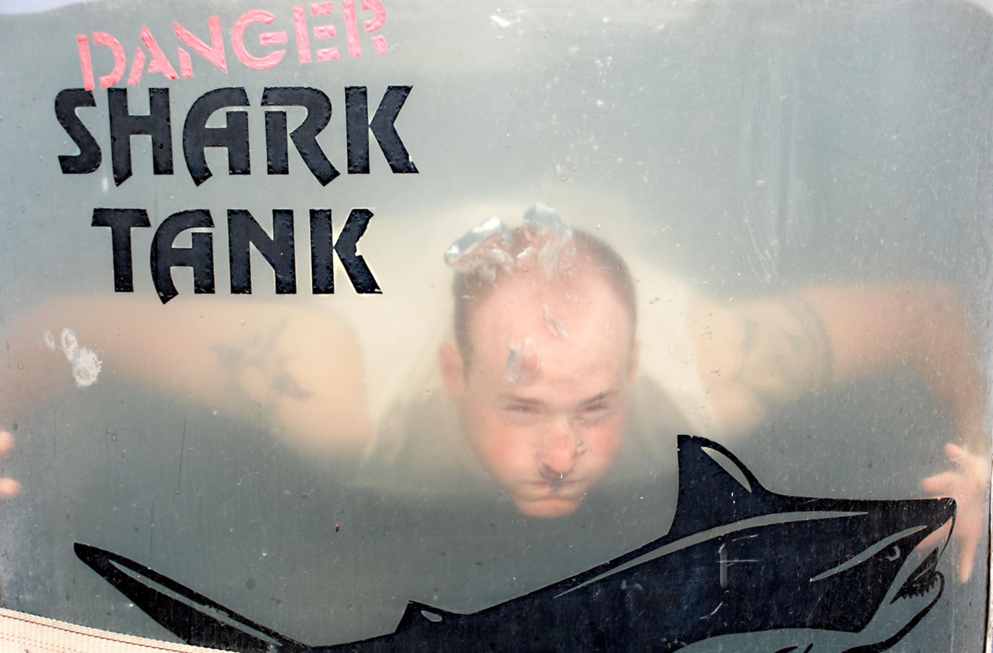 Airman 1st Class Chris Gargus, Rising 6 airman president, lands at the bottom of a dunk tank during the Block Party June 20. Airman Gargus volunteered for a position in the tank for a chance to taunt passerbys. 