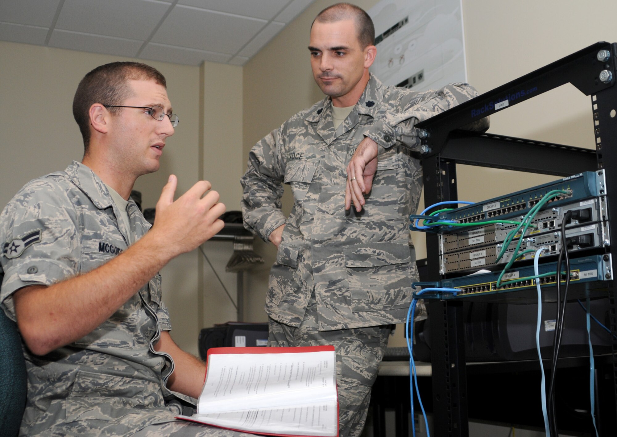 Left, Airman 1st Class Stephen McGuire tells Lt. Col. Russell Voce what he’s learned so far in the communication operations course about using networking equipment.  The colonel is the new commander of the 336th TRS.  (U.S. Air Force photo by Kemberly Groue)