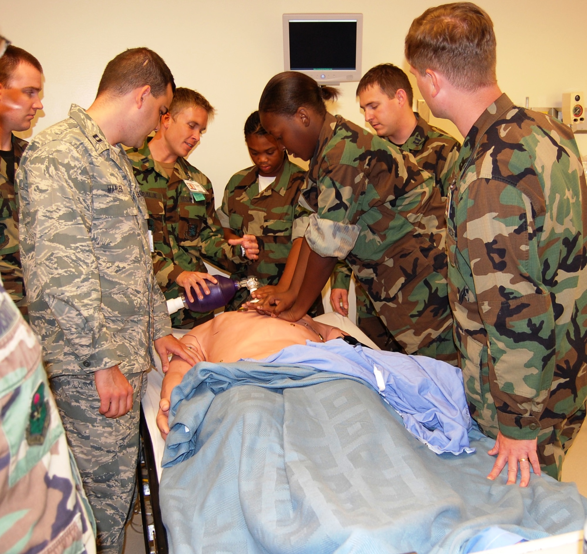 A Junior Life Changer practices cardiopulmonary resuscitation on a medical simulator as some new surgical and internal medicine residents instruct her on proper technique.  (U.S. Air Force photo by Steve Pivnick)
