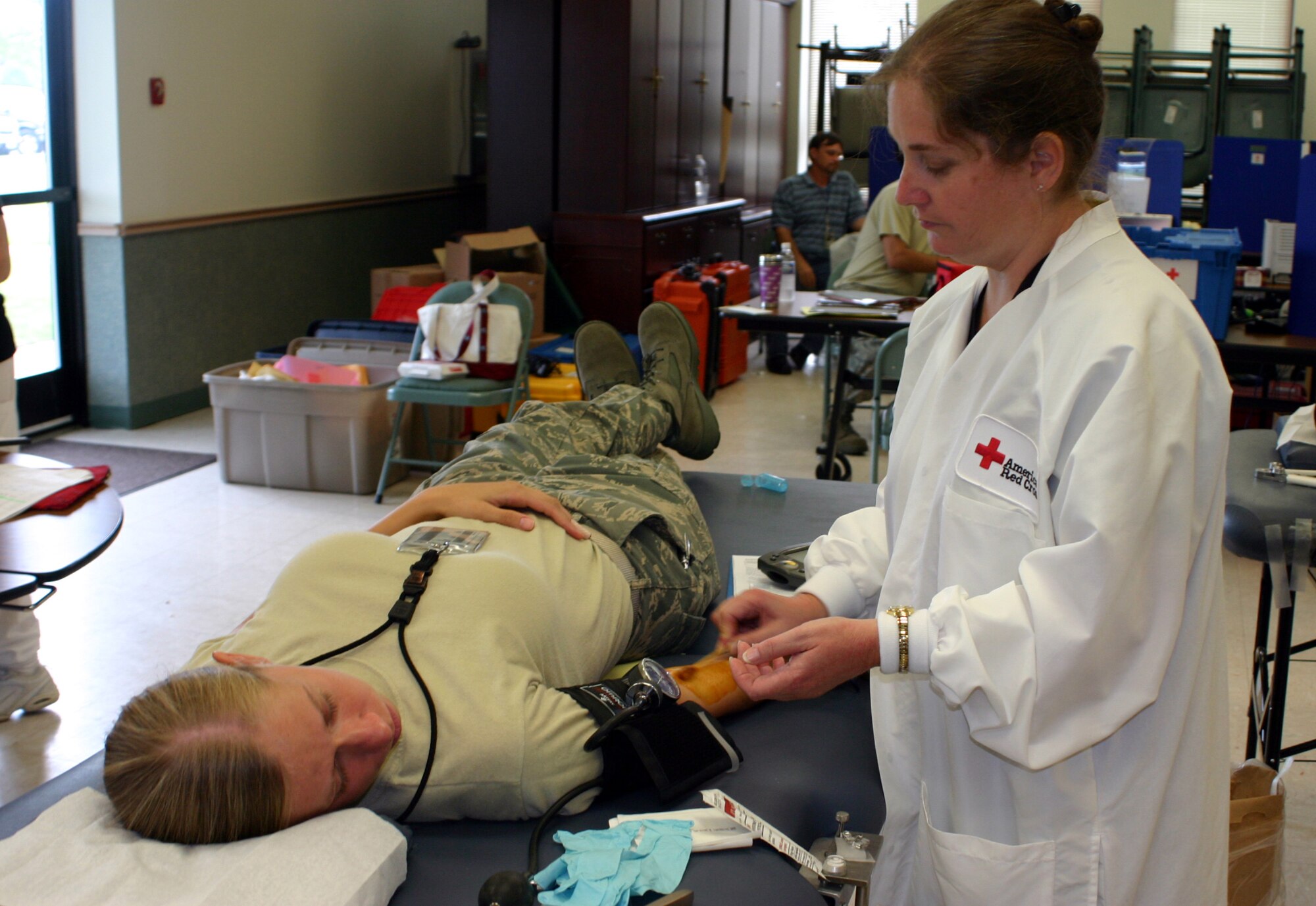 Georgeann Seril, American Red Cross donor collection assistant, prepares Staff Sgt. Lynn Plemons, 305th Maintenance Squadron aircraft structural maintenance technician, to donate blood July 9 here. The two-day blood drive collected more than 130 life-saving blood donations. Remember, every two seconds someone in the United States needs blood, and volunteers can save up to three lives with just one donation. For more blood donation opportunities, visit www.givelife.org or call (800) GIVELIFE. (U.S. Air Force photo/Airman 1st Class Bekah Phy)      