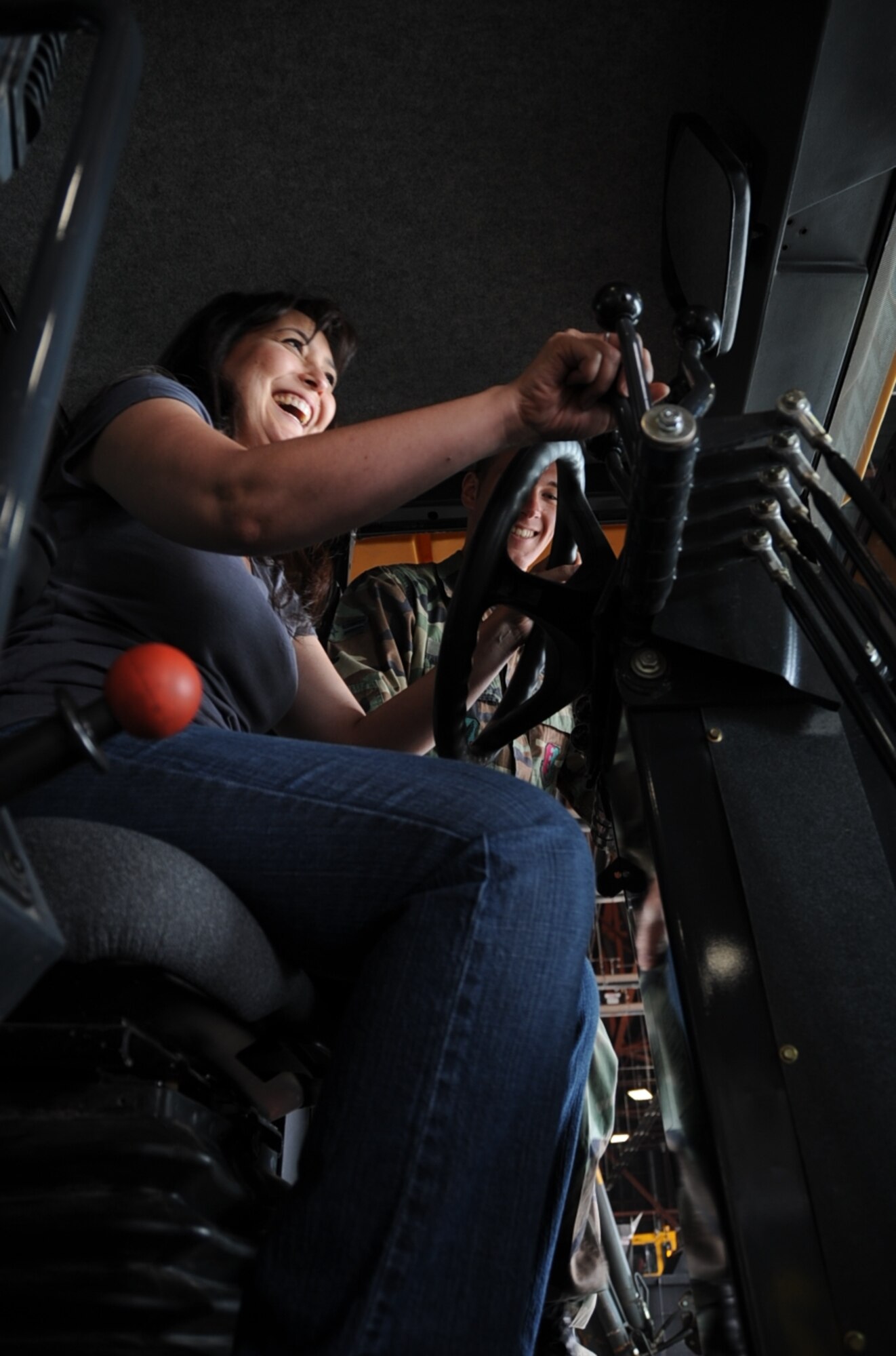 Sheryl Cronan, spouse of Chief Master Sgt. Robert Cronan 28th Civil Engineering Squadron superintendent, operates a Front End Bucket Loader during 28th CES Spouse Day here July 3. All Airmen from 28th CES had the opportunity to show their spouses what they do in the Air Force. (U.S. Air Force photo/Senior Airman Anthony Sanchelli)