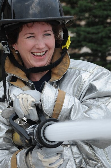 Suzanne Allen, spouse of Lt. Col. John Allen, 28th Civil Engineering Squadron commander, sprays a simulated fire during 28th CES Spouse Day here July 3. All Airmen from 28th CES had the opportunity to show their spouses what they do in the Air Force. (U.S. Air Force photo/Senior Airman Anthony Sanchelli)