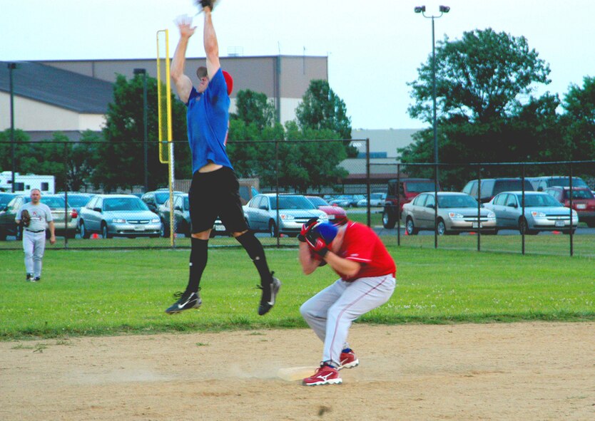 AFOSI Gators' left fielder Spencer Rogers ducks under a high throw by an 89th Operations Group player after a stand up double. The Gators took two from the 89th OG, 23-9 and 12-6 respectively, to up their record to 6-0. (U.S. Air Force photo/Tech. Sgt. John Jung)