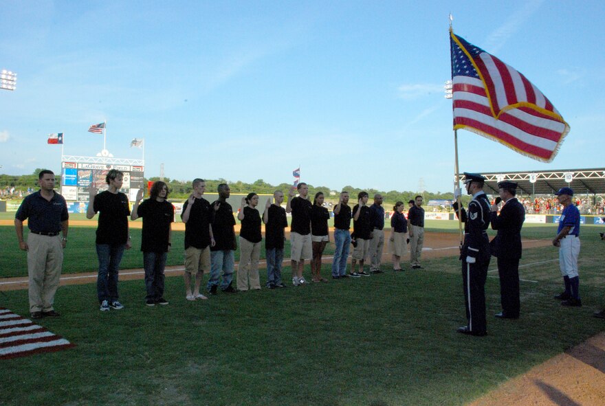 Brig. Gen. Thomas Coon, 10th Air Force commander (right of flag held by Tech. Sgt. Lyndsay Estell), enlisted ten new Air Force Reserve Airman in front of a record-sized crowd during the third inning of the July 4 Fort Worth Cats baseball game. (U.S. Air Force Photo/Tech. Sgt. Julie Briden-Garcia)