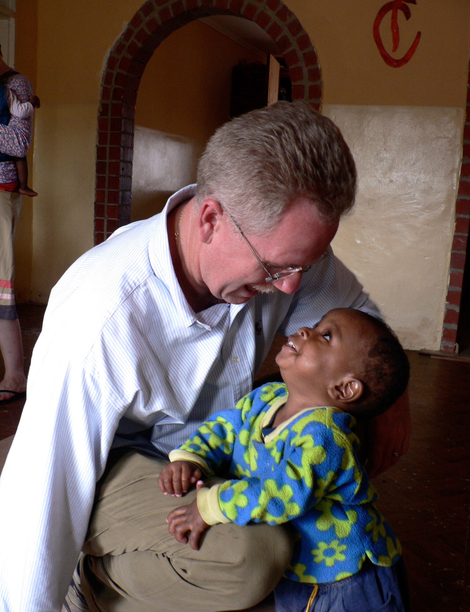Pediatric Cardiologist Lt. Col. (Dr.) Kirk A. Milhoan, 59th Maternal/Child Care Squadron, spends a moment with Simon, who was brought to a Zambia orphanage very close to death. With care and treatment he received there, Simon was able to once again be a vibrant and energetic child. The orphanage in Kitwe, Zambia, was founded in 2003 with the help of Dr. Milhoan. (Courtesy photo)