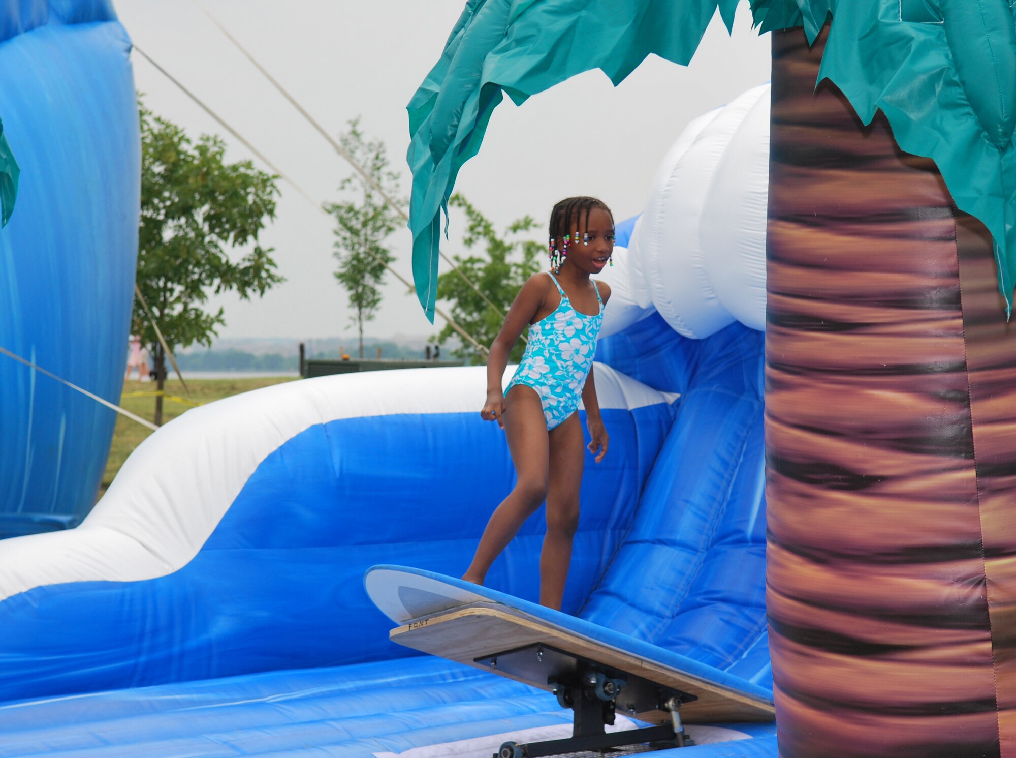 A Bolling youth takes a ride on the surf simulator July 4 during the 6th Annual Freedom Fest at Bolling Green Park. (U.S. Air Force photo by Senior Airman Edward Carr)
