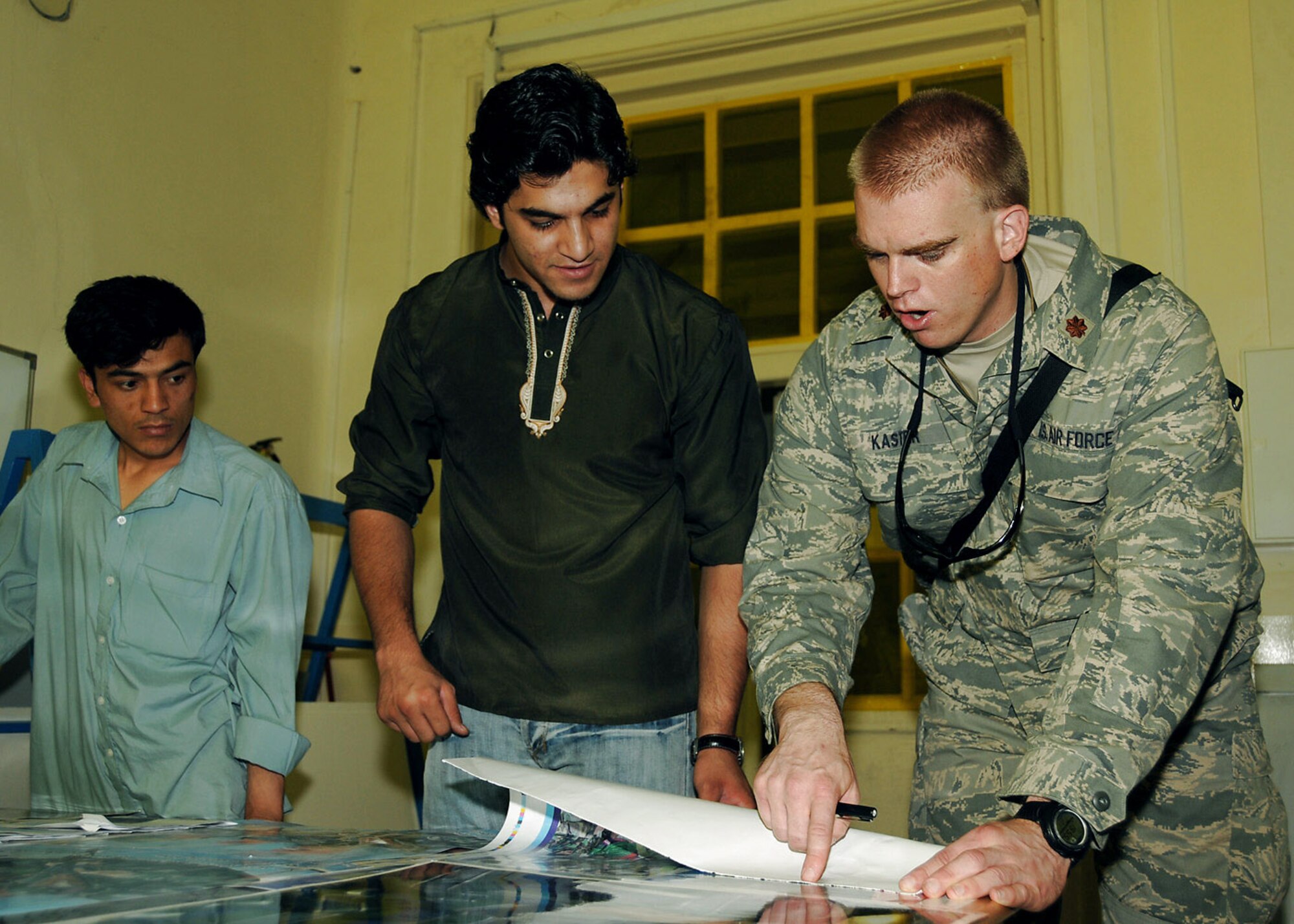 Maj. Paul Kaster discusses a print job with an Afghan National Army civilian at the ANA print plant in Kabul, Afghanistan. During an average week, the plant produces more than 75,000 products used for training, recruitment and logistical support. Major Kaster is a Combined Security Transition Command-Afghanistan Afghan National Army communications mentor. (U.S. Air Force photo/Staff Sgt. Beth Del Vecchio)