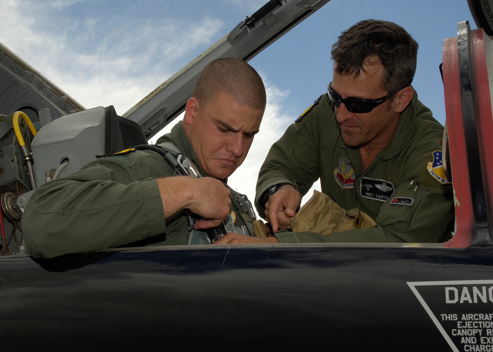 Maj. Bret Carter, 49th Fighter Wing Chief of F-22 Advanced Programs office, helps U.S. Air Force Academy Cadet Zach Mattee get strapped in before his incentive flight at Holloman Air Force Base, N.M., June 25. Cadets visited Holloman as part of the Operations Air Force program to shadow officers and enlisted members. (U.S. Air Force photo/Airman 1st Class Michael Means)