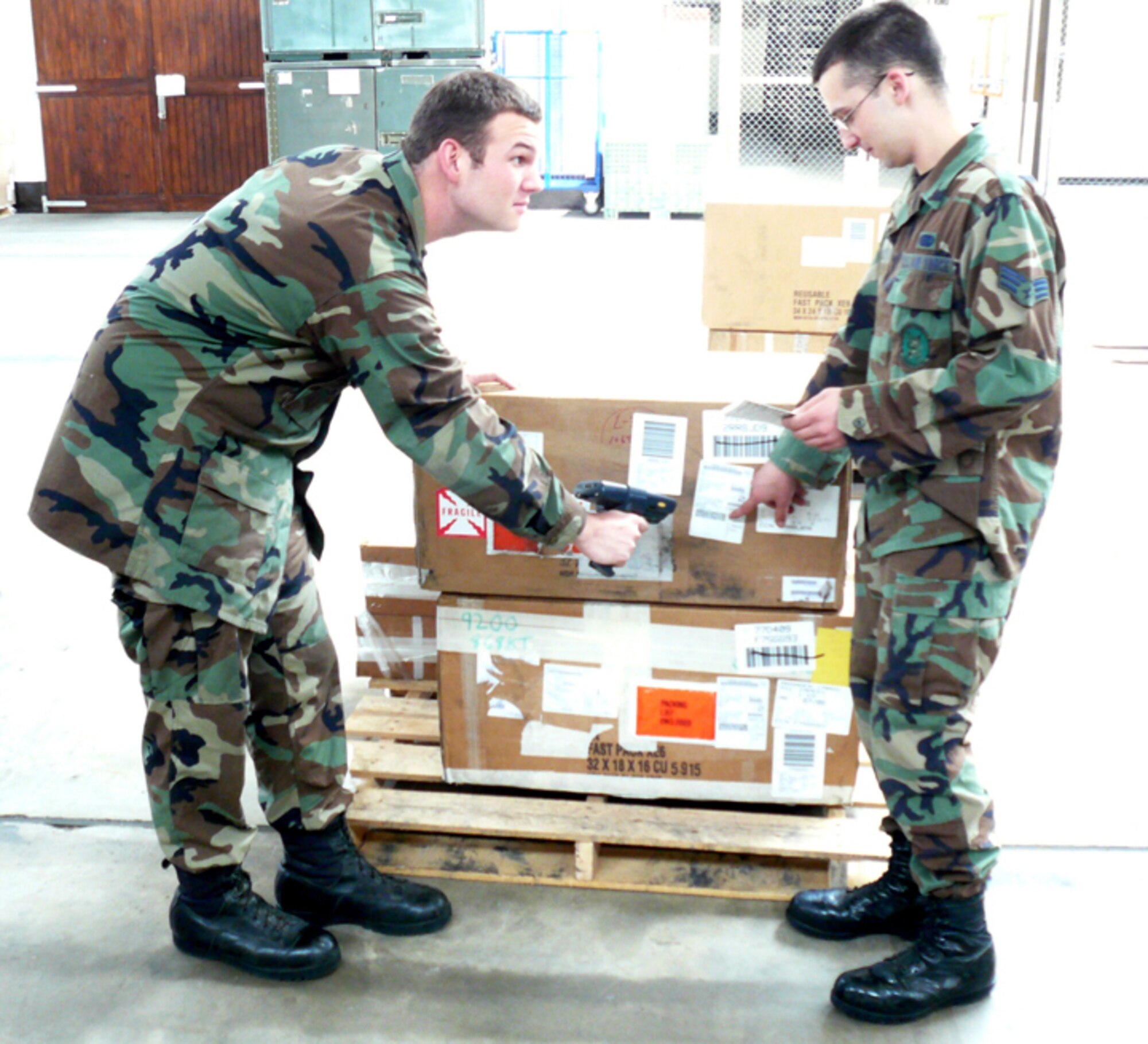 RAF MILDENHALL, England -- Airman 1st Class Justin Hawley, 100th Logistics Readiness Squadron, shows Cadet 2nd Class Matthew Haxton how to receive supply assets. U.S. Air Force Academy cadets will visit RAF Mildenhall over the course of the summer as part of Operation Air Force, a mentorship program designed to show cadets what active-duty Airmen do every day. (U.S. Air Force photo by Capt. Stephen Rosenthal)