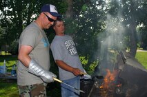 MINOT AIR FORCE BASE, N.D. -- Staff Sgt. Corbin McIntire, 5th Bomb Wing safety , and Minot local, Robert Ogden, cook up some hamburgers for hungry patriots here July 4. Minot Air Force Base’s annual Fourth of July picnic and fireworks display went off with a bang, highlighted by a spectacular fireworks display. The event was hosted by Community Center and 5th Force Support Squadron, which provided fun and entertainment for base residents. (U.S. Air Force photo by Senior Airman Kelly Timney)