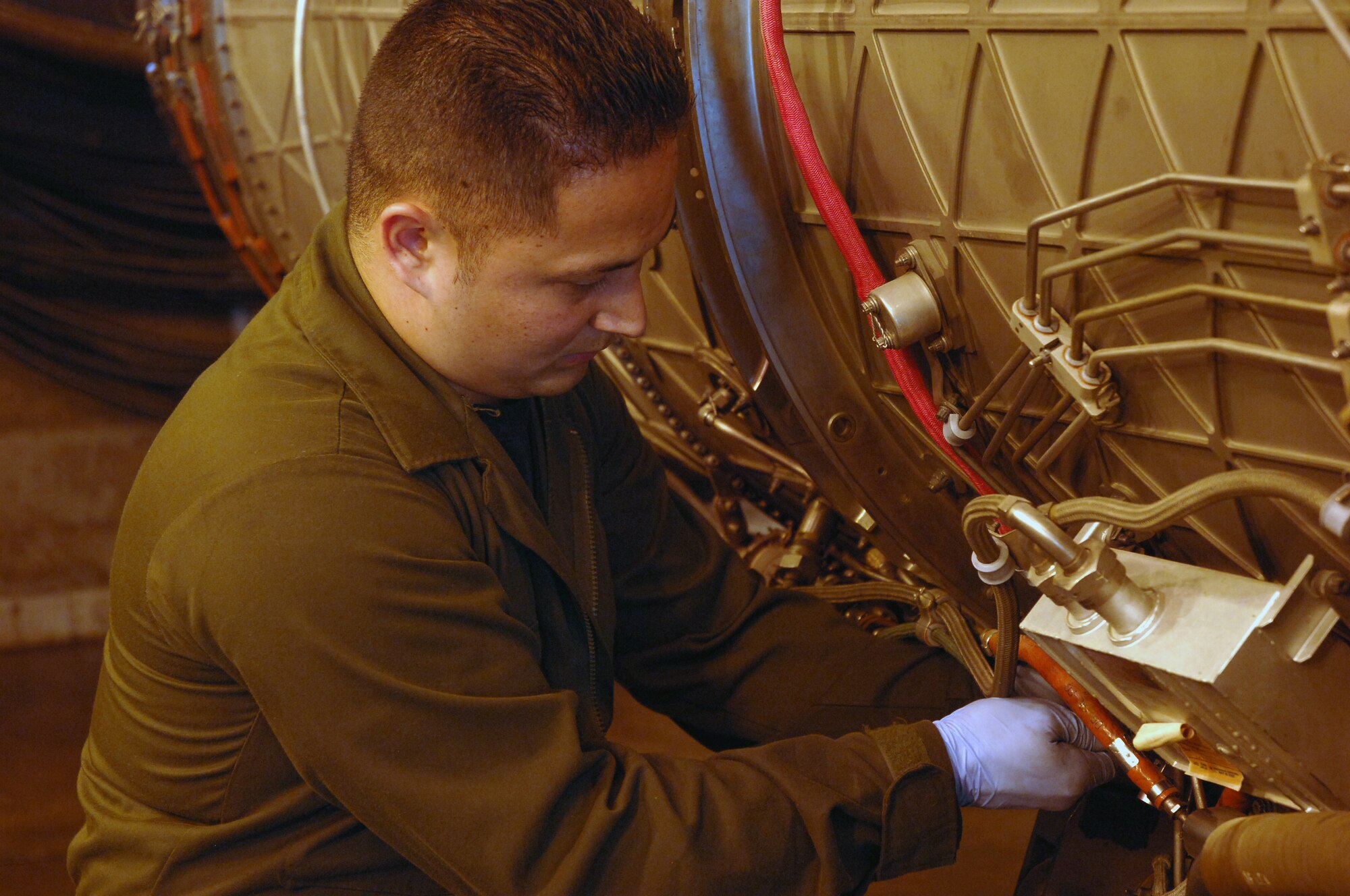 Staff Sgt. Justin Keane, 48th Component Maintenance Squadron, attaches an F-15 jet engine to a motorized mount that will raise the engine into position so it can be tested in the “hush house.”  CMS tests more than 15 engines every month. (U.S. Air Force Photo by Master Sgt. Edward Bard)