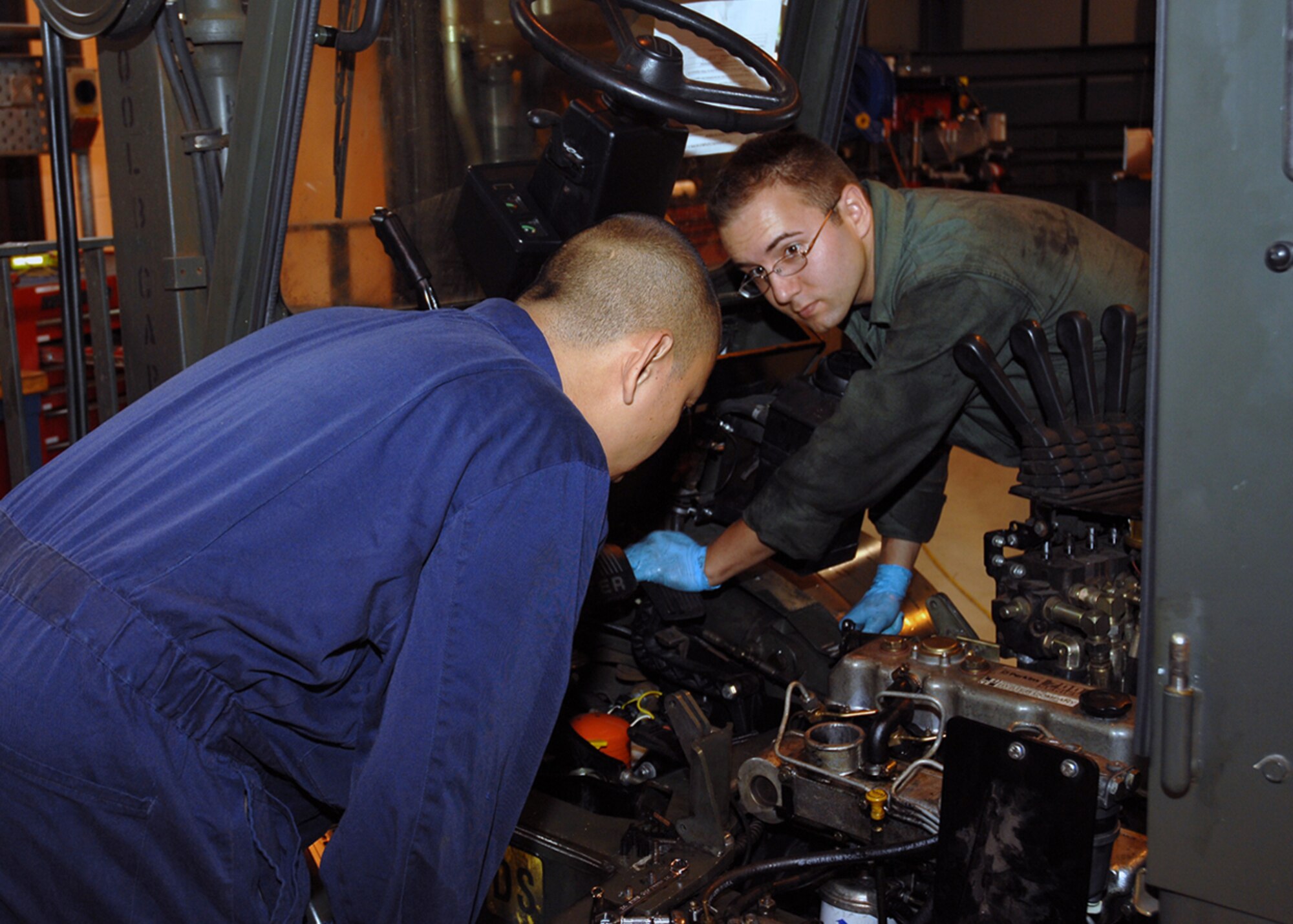 Airman 1st Class Alex Andrejkobics, 48th Logistics Readiness Squadron vehicle and equipment repair mechanic, learns how to rebuild a forklift engine from Staff Sgt. Alberto C. Gatcho, 48th LRS special purpose vehicle mechanic. Sergeant Gatcho explained that the diesel fuel was not making it to the engine of the forklift. The engine shut down and Sergeant Gatcho and Airman Andrejkobics were rebuilding it. (U.S. Air Force photo by Airman 1st Class Jessica Donnelly)