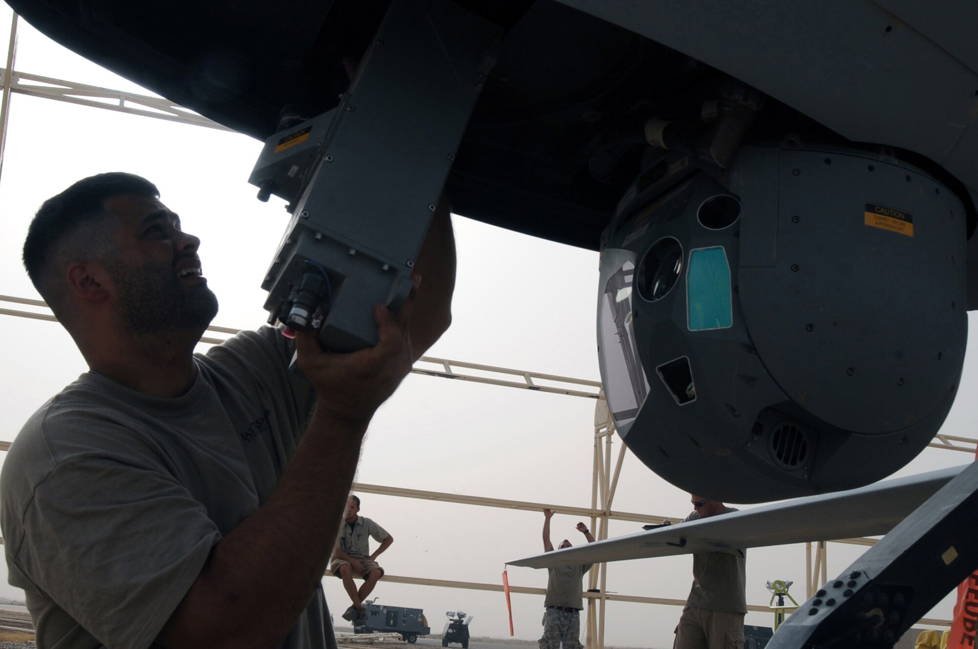 ALI BASE, Iraq -- Schuyler Dunn, 361st Expeditionary Reconnaissance Squadron aircraft technician, replaces a part of the Multispectural Targeting System Ball on the Predator MQ-1B Unmanned Aerial Vehicle here July 9. Through the use of advanced capabilities, focused doctrine and detailed training the predator provides integrated and synchronized close air combat operations, to include intelligence, surveillance and reconnaissance. (U.S. Air Force photo/Tech. Sgt. Sabrina Johnson)