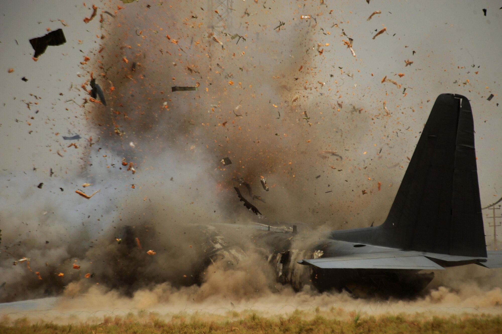 BAGHDAD, Iraq -- Explosive Ordinance Disposal personnel from the 447th Expeditionary Civil Engineer Squadron at Sather Air Base detonate explosives to separate the forward section of a C-130 Hercules here July 7. The EOD team is using a series of controlled detonations designed to divide the airplane into smaller pieces so it can be easily moved. The C-130 made an emergency landing in a field north of Baghdad International Airport shortly after take-off June 27. (U.S. Air Force photo/Tech. Sgt. Jeffrey Allen)