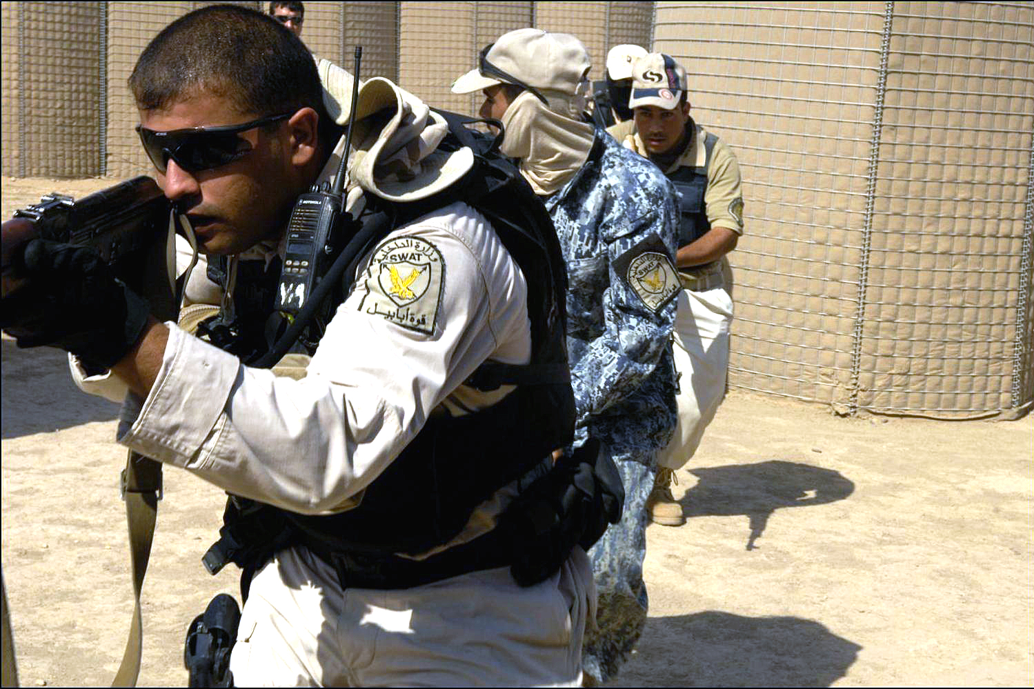 Iraqi Special Weapons and Tactics, or SWAT, police officers move through a  shoot-house training facility