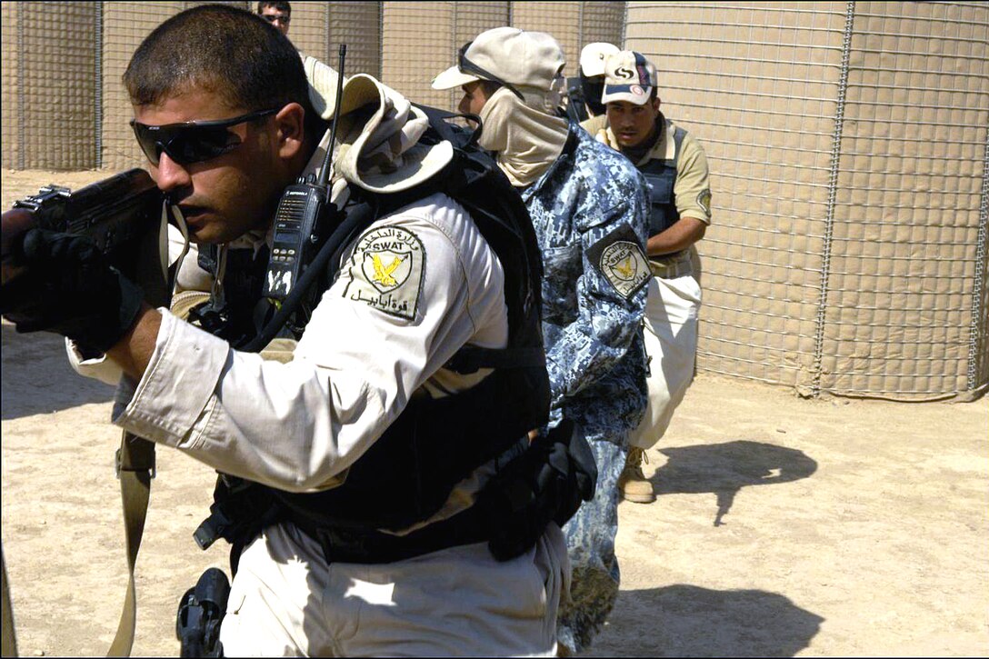 Iraqi Special Weapons and Tactics, or SWAT, police officers move through a shoot-house training facility during a close-quarter combat training exercise on Camp Echo, Iraq, July 6, 2008. 
