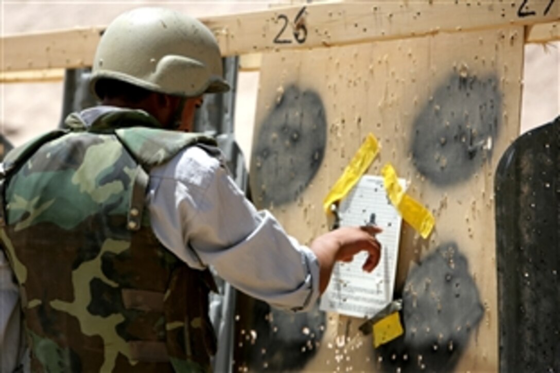 An Iraqi police recruit assesses his shot grouping after firing a Glock pistol from the 15-yard line during a fire exercise at a range on Camp Ramadi, Iraq, July 3, 2008. U.S. Marines assigned to the 1st Battalion, 9th Marine Regiment, Regimental Combat Team 1 are overseeing the training of Iraqi police.