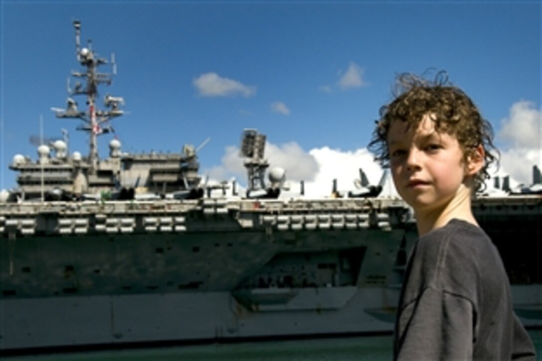 A boy says goodbye to USS Kitty Hawk as it departs Naval Station Pearl Harbor, Hawaii, July 8, 2008, to participate in Rim of the Pacific 2008. RIMPAC is a biannual exercise hosted by U.S. Pacific Fleet that brings together military forces from Australia, Canada, Chile, Peru, Japan, the Netherlands, Singapore, the United Kingdom and the Republic of Korea.