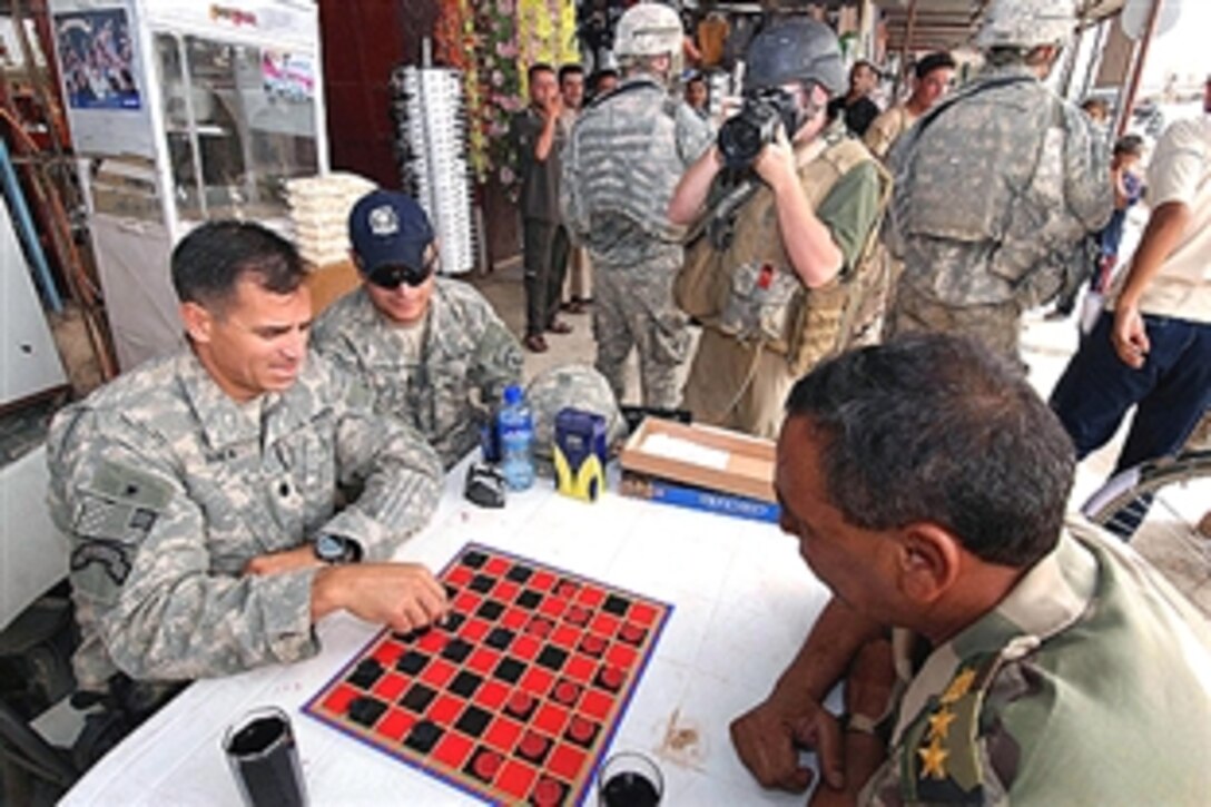 U.S. Army Lt. Col. Christopher Vanek, left, plays checkers with  Khalaf Ibrahim Ali, a contract employee for the local "Sons of Iraq" citizens group,  in a market in downtown Hawijah, Iraq, July 8, 2008. Vanek is commander of the 10th Mountain Division's 1st Battalion, 87th Infantry Regiment.