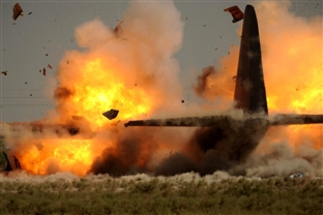 U.S. Air Force explosive ordnance disposalmen detonate explosives attached to the wings of a C-130 Hercules aircraft at Sather Air Base, Iraq, July 7, 2008. The aircraft was disabled after it made an emergency landing last month, and the airmen used a series of controlled detonations to divide the aircraft into smaller pieces so it could be moved. The disposalmen are assigned to  the 447th Air Expeditionary Group.