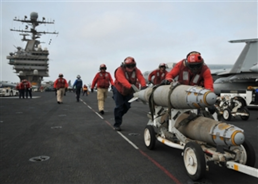 U.S. Navy aviation ordnancemen prepare to load ordnance onto aircraft on the flight deck of the Nimitz-class aircraft carrier USS Abraham Lincoln (CVN 72) while underway in the Gulf of Oman on July 8, 2008.  The Lincoln is deployed to the U.S. Navy 5th Fleet area of responsibility in support of maritime security operations.  