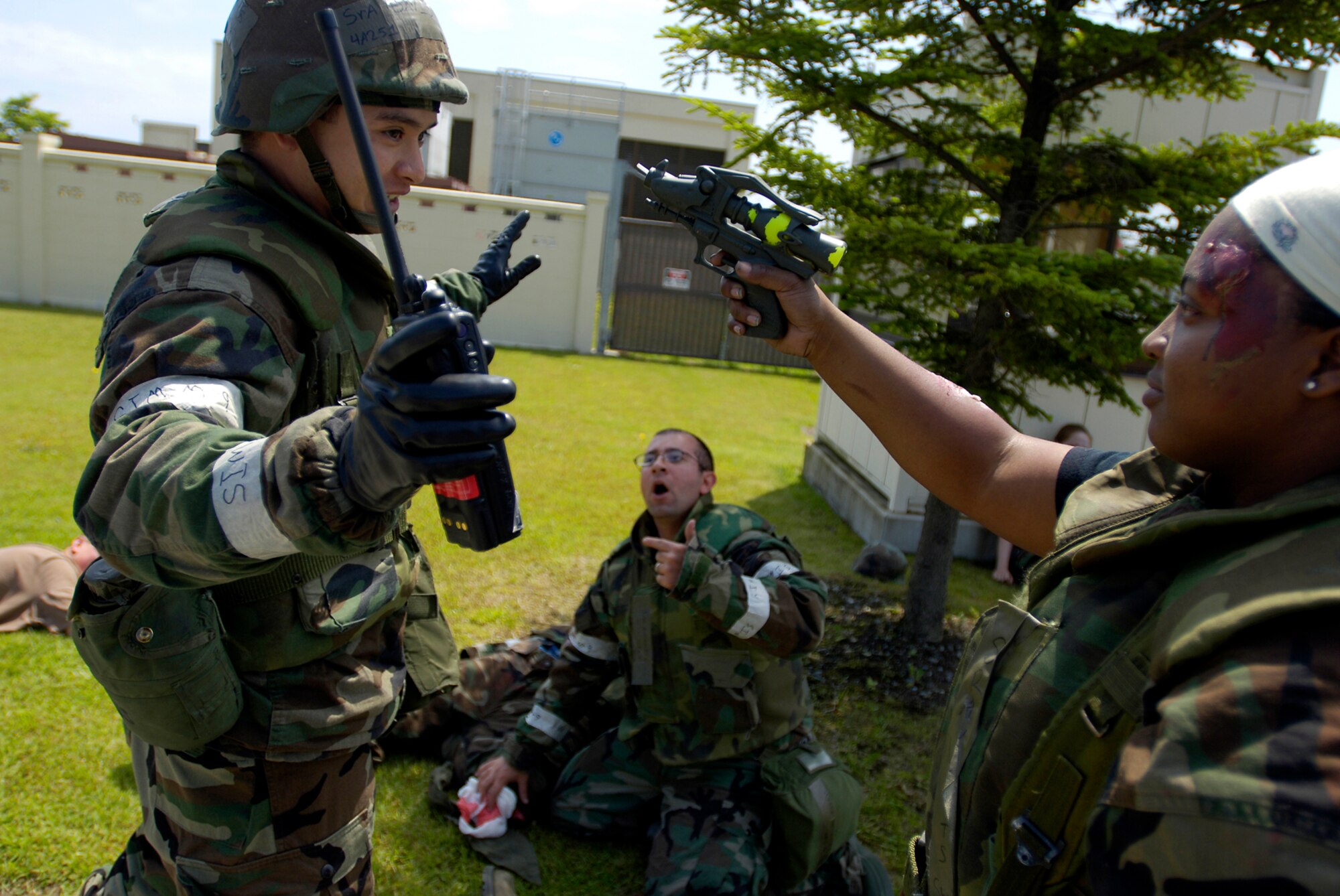 MISAWA AIR BASE, Japan -- A simulated wounded Airman holds a gun to another Airman's head in an attempt to get treatment for her injured wingman during exercise Beverly Sunrise June 26, 2008.  Role players play a vital role in exercises. They provide realistic scenarios to test responses of the players.  (U.S. Air Force photo by Senior Airman Chad Strohmeyer)
