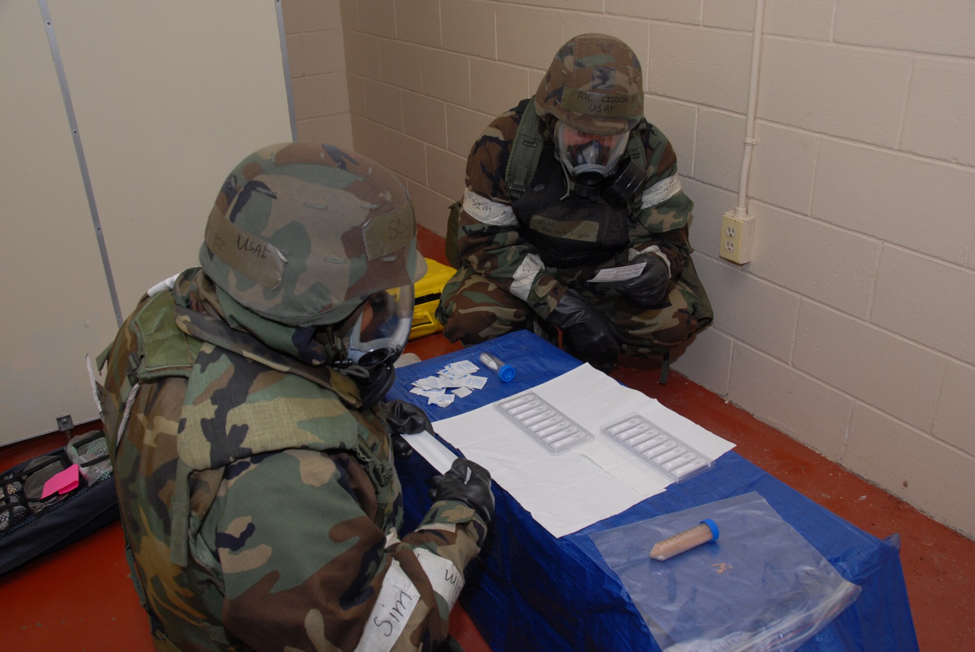 MISAWA AIR BASE, Japan -- Staff Sgt. Joseph Ramirez, 35th AMDS, and Airman 1st Class Christopher Liggon, 35th CES, use a handheld assay to identify an unknown substance during a combat employment readiness exercise June 25, 2008.  Handheld assays are used to look for protein in unknown substances.   (U.S. Air Force photo by Senior Airman Laura McFarlane)