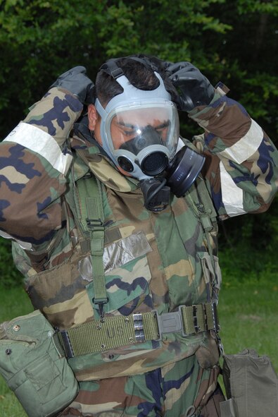 MISAWA AIR BASE, Japan -- Staff Sgt. Joseph Ramirez, 35th Aerospace Medical Squadron, dons his gas mask before examining an unidentified substance during a combat employment readiness exercise June 25, 2008.  The 35th Fighter Wing participated in an exercise June 24 - 26 to test their combat capabilities in a wartime environment.  (U.S. Air Force photo by Senior Airman Laura McFarlane)