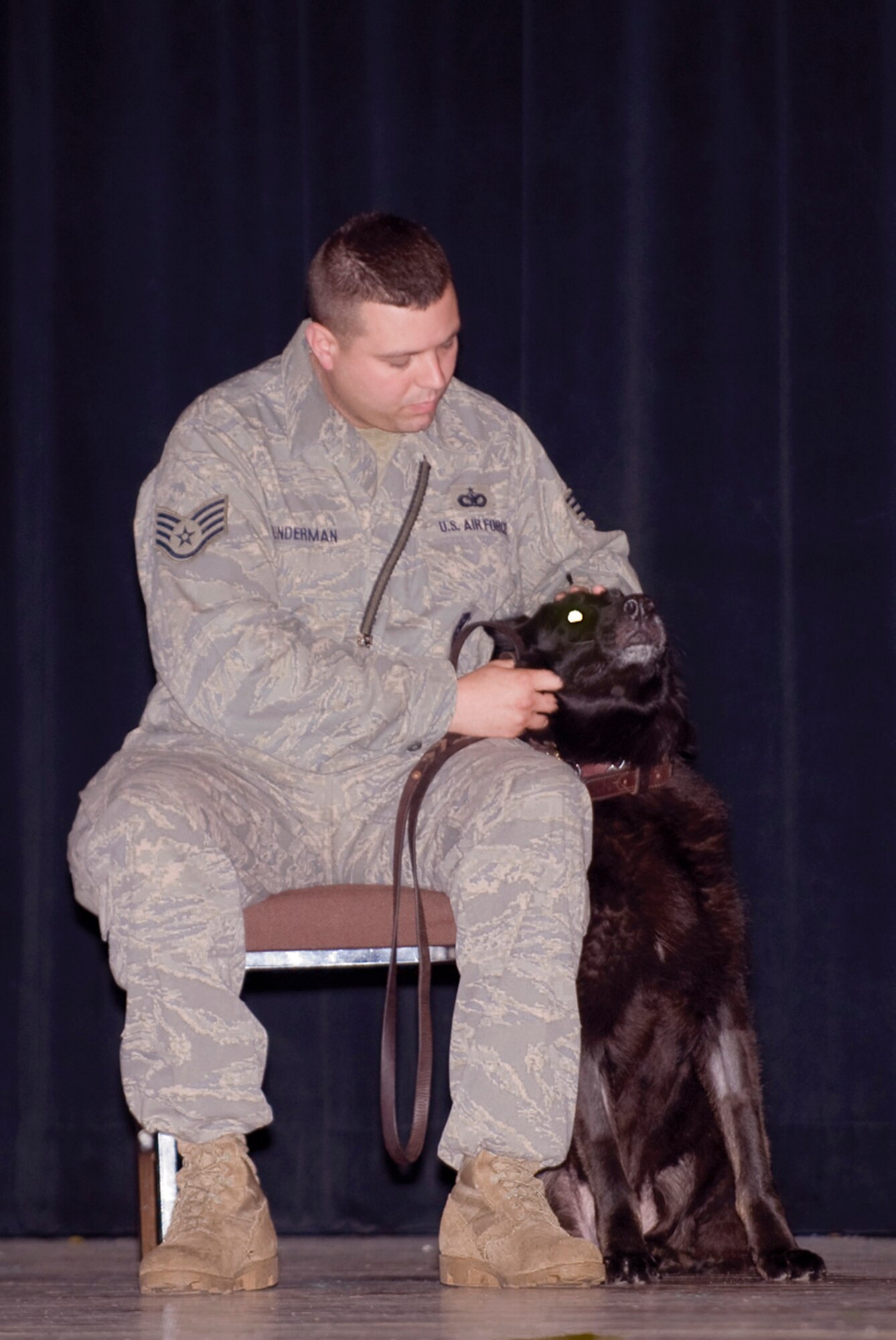 ELMENDORF AIR FORCE BASE, Alaska ? Military working dog Arko sits next to his handler Staff Sgt. Christopher Gunderman 3rd Security Forces Squadron during his retirement ceremony on July 7, 2008. Arko has served 11 years in the Air Force and been deployed 5 times to the Middle East. (U.S. Air Force photo by Senior Airmen Jonathan Steffen)