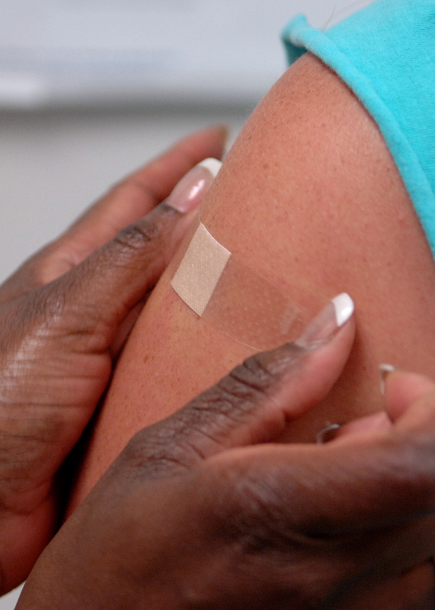 Tech. Sgt. Cassandra Williams, 49th Aeromedical Dental Squadron, applies a bandage in the 49th Medical Group's Immunization Clinic at Holloman Air Force Base, N.M., July 9. (U.S. Air Force photo/Airman 1st Class John Strong) 
  