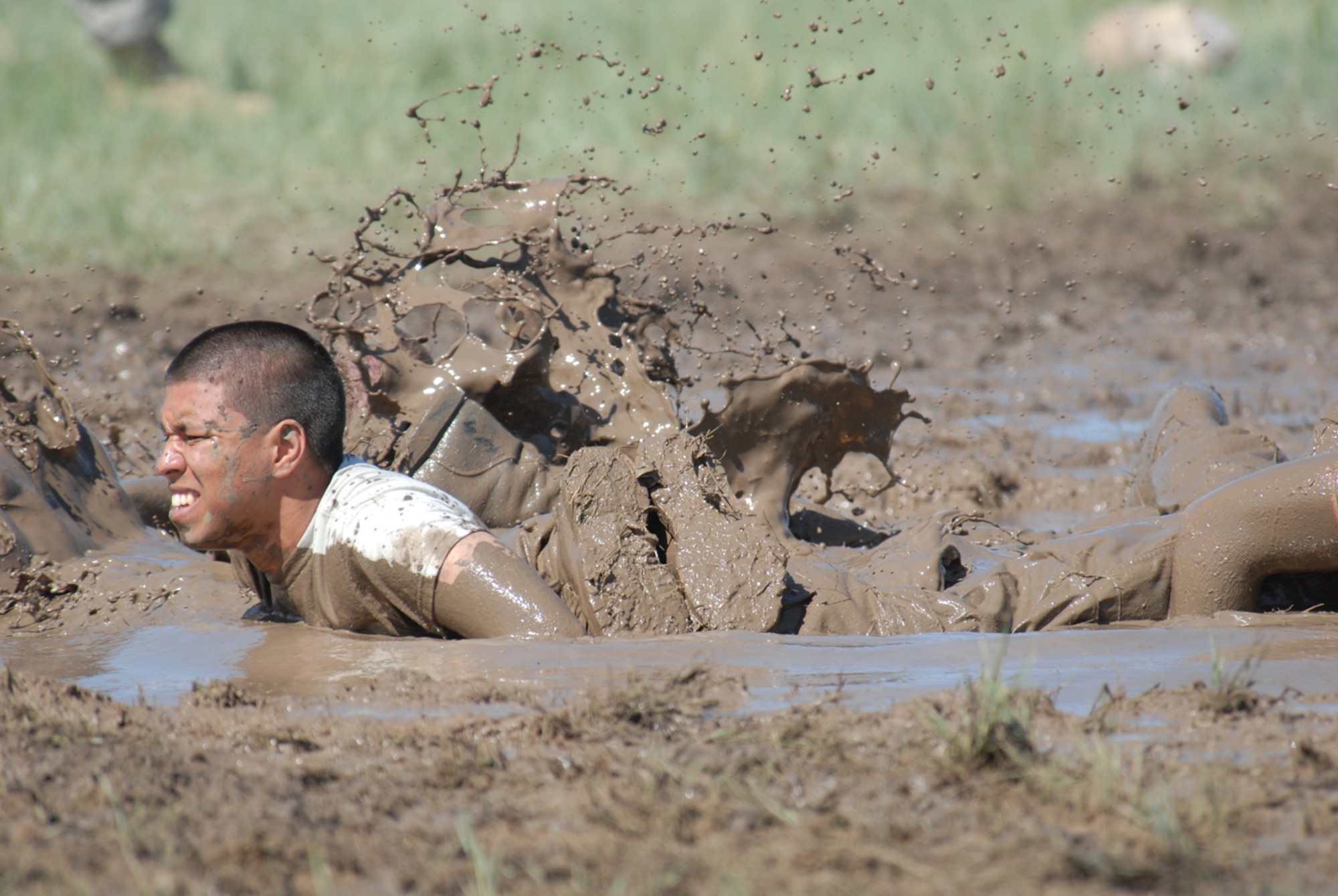 An Airman crashes into the mud during the Team Pain portion of the Crow Creek Challenge June 26. Team Pain requires the team to do four-man push ups, carry a log a certain distance and then fireman carry each other back to the mud hole. The object of this part of the competition is to do as many repetitions of the cycle as possible in an allotted time period (Photos by Shelley Raffl).