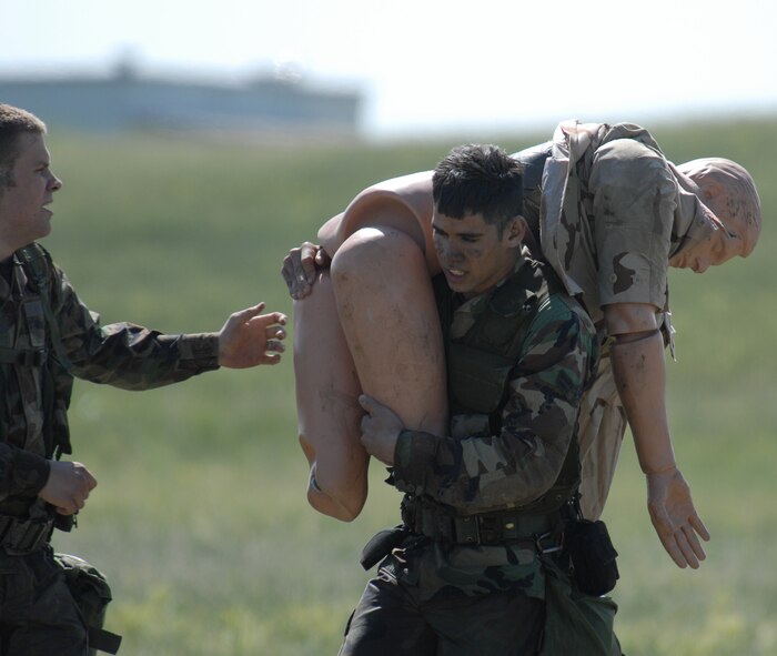 An Airman carries a mannequin to his teammates during the Crow Creek Challenge June 26. The mannequin weighed the same amount an average person would weigh.