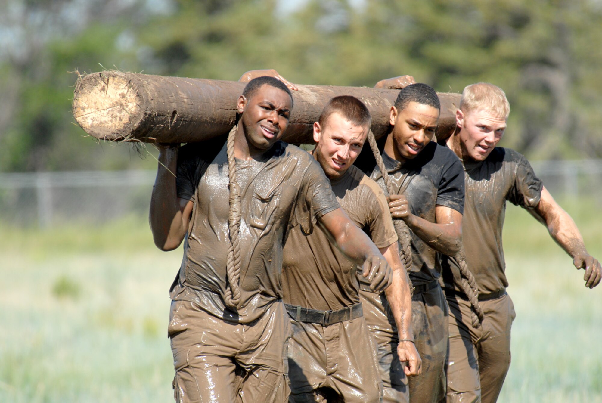 A team carries a log back to the mud hole of the Team Pain portion of the competition during the Crow Creek Challenge June 26. Some consider Team Pain to be the hardest obstacle of the entire challenge. 