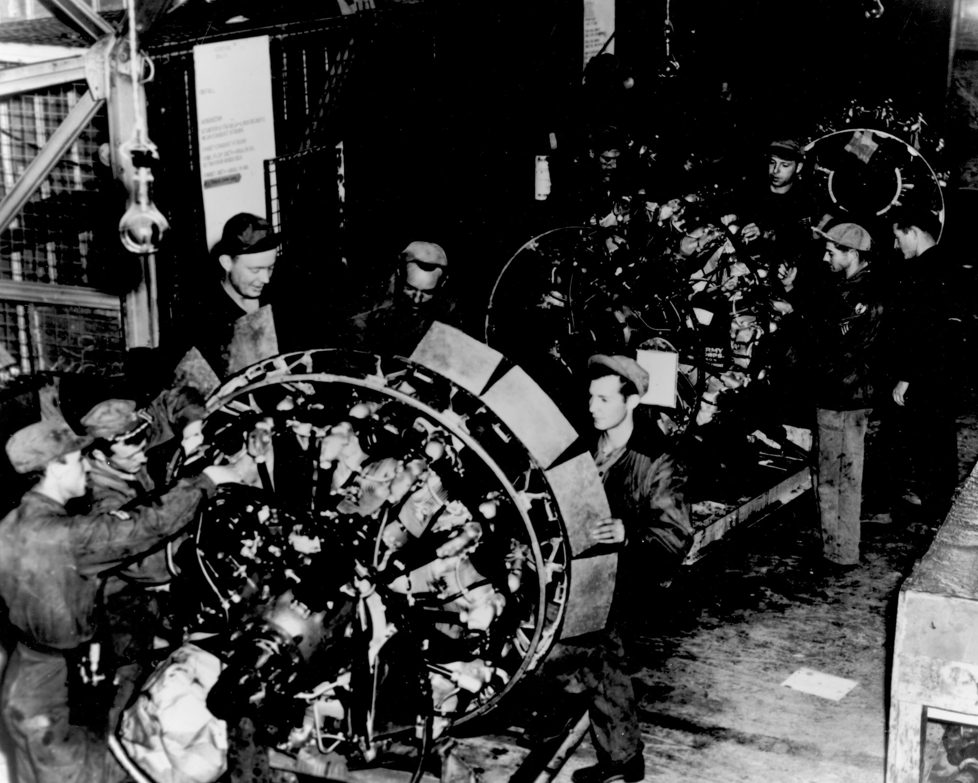 Workers service an engine on the engine buildup line at Rhein Main Air Base, Germany in 1948. Here the engines used on C-54 Skymasters flying the airlift to Berlin were disassembled, checked, worn parts replaced, reassembled and returned to service on the aircraft. (Courtesy photo)