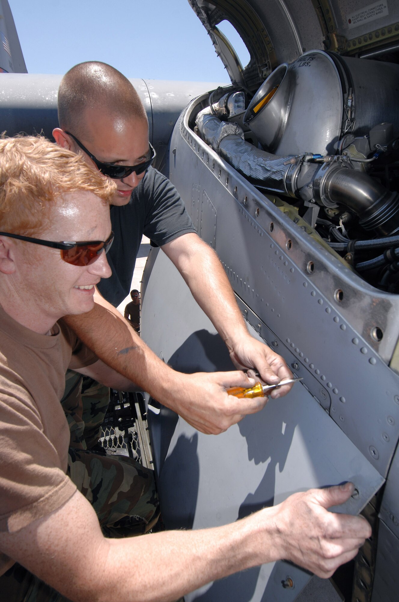 Staff Sgt. Ralph Beauvais and Staff Sgt. Joe Burriss take the cowling off a C-130 Hercules engine July 4 to perform some maintenance on the aircraft before it flies out of McClellan Airfield, Calif., on its next airborne firefighting support mission.  The two sergeants are assigned to the North Carolina Air National Guard's 145th Airlift Wing and are in California to assist with firefighting operations as part of the 302nd Air Expeditionary Group.  (U.S. Air Force photo/Staff Sgt. Hector Garcia)