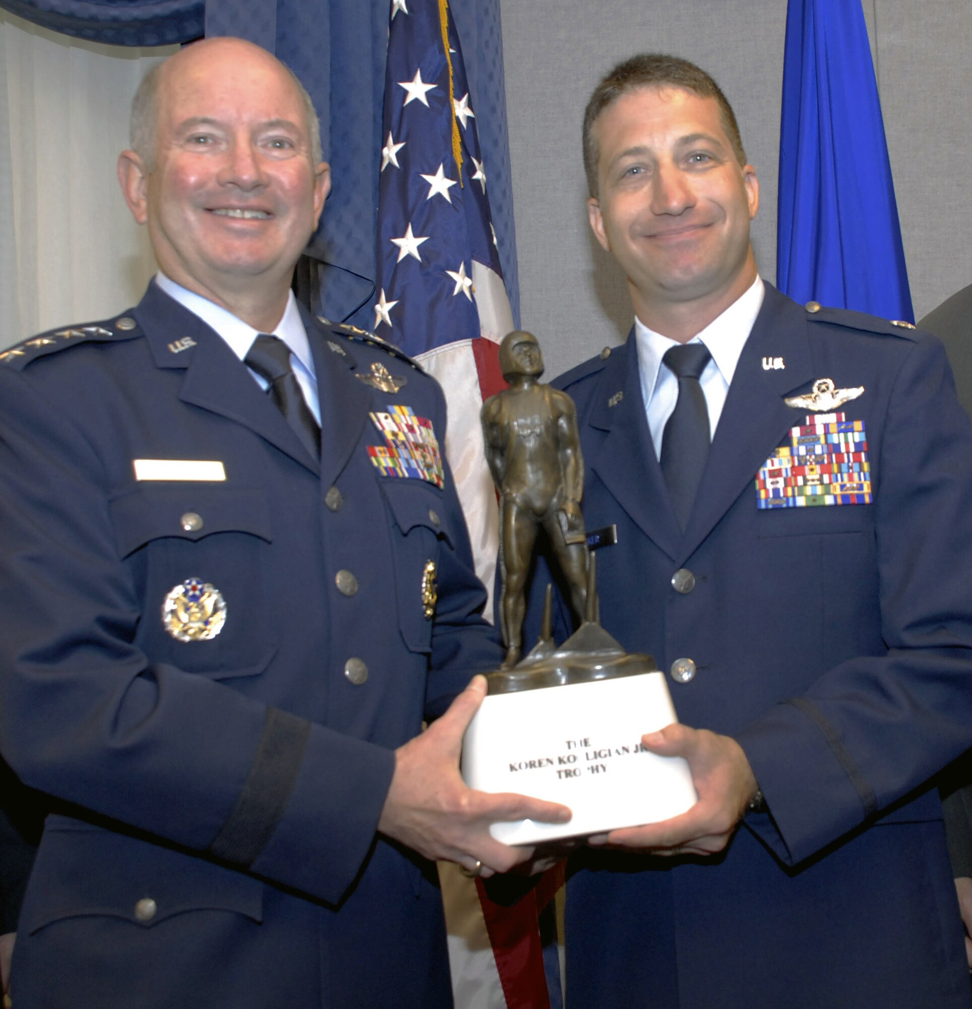 Vice Chief of Staff Gen. Duncan J. McNabb presents Lt. Col. Eugene Becker, 20th Special Operations Squadron, the Koren Kolligian Jr. trophy during a recent ceremony at the Pentagon. Colonel Becker was flying an MH-53M Pave Low helicopter on a training mission when it suffered a "catastrophic mechanical failure." Colonel Becker and his crew were able to safely land the helicopter, saving the lives of all seven crewmembers. (U.S. Air Force photo/Staff Sgt. J.G. Buzanowski) 