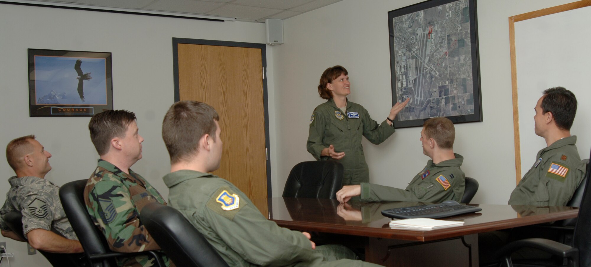 MCCONNELL AIR FORCE BASE, Kan. -- Major Leslie Maher, 22nd Air Refueling Wing Plans and Programs chief, briefs fellow team members on location of upcoming exercises at building 1, July 9. Plans and programs office prepares for upcoming exercises to prepare Team McConnell for success.   (Photo by Senior Airman Roy Lynch)