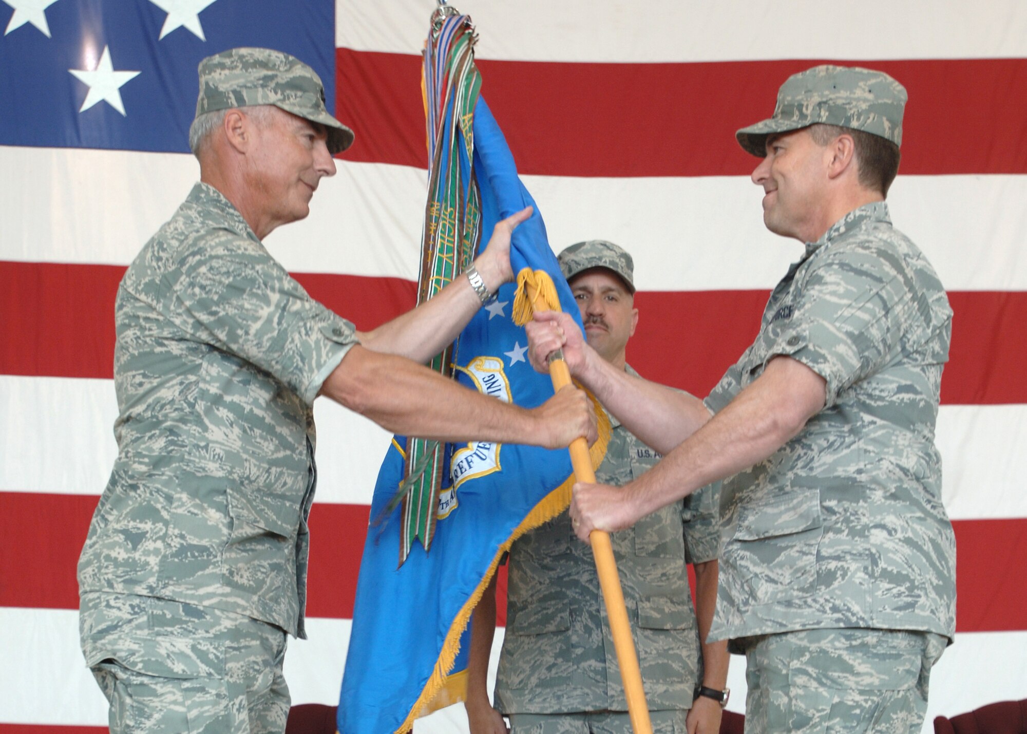 Maj. Gen. Winfield Scott, 18th Air Force Commander (pictured left), passes the guidon of leadership to Col. John Michel during a change of command ceremony here July 9. Colonel Michel’s goals for the wing are to build upon the foundation of excellence developed over the past five decades. (U.S. Air Force photo/Staff Sgt. Suellyn Nuckolls)