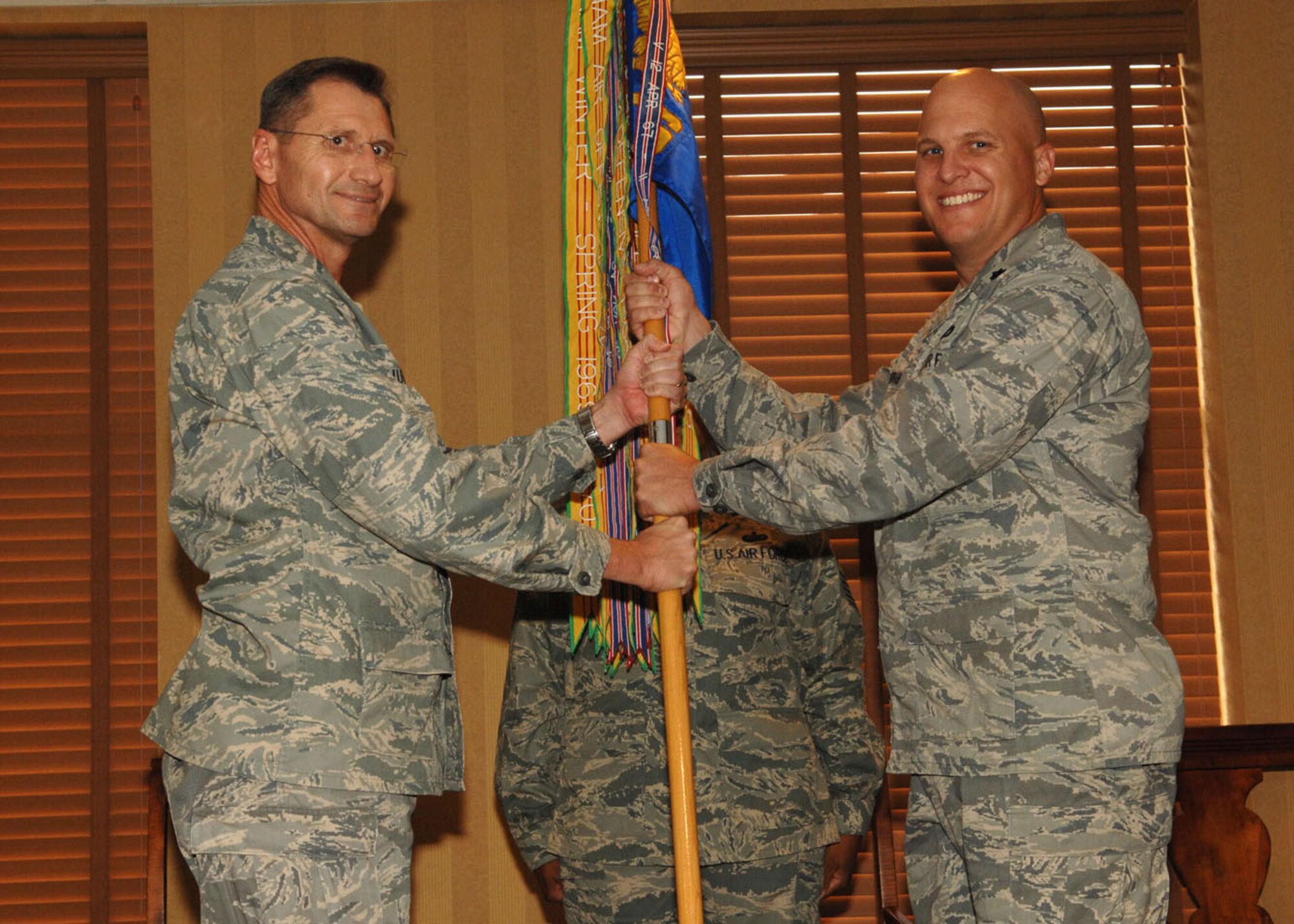 Lt. Col. Charles Perham receives the 355th Civil Engineer Squadron guidon  from Col. Charles Hunter, 355th Mission Support Group commander during a change-of-command ceremony here July 8.  Colonel Perham took over command of the 355th CES after serving as the executive officer to the Civil Engineer, Headquarters United States Air Force, Office of the Civil Engineer, Pentagon, Washington D.C.  (U.S. Air Force photo by Senior Airman Alesia Goosic)