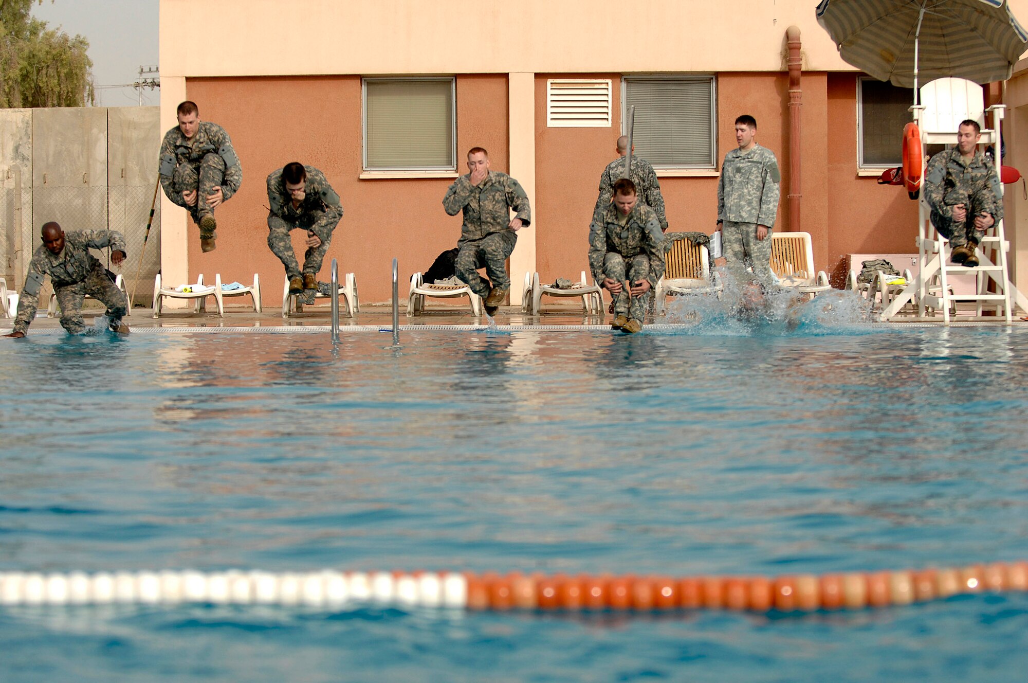 Airmen from the 332nd Expeditionary Civil Engineer Squadron explosive ordnance disposal flight jump into the pool for water skills training at Joint Base Balad, Iraq, July 8. Performing the training in full uniform replicates what the circumstances could be during water operations. (U.S. Air Force photo/Senior Airman Julianne Showalter)