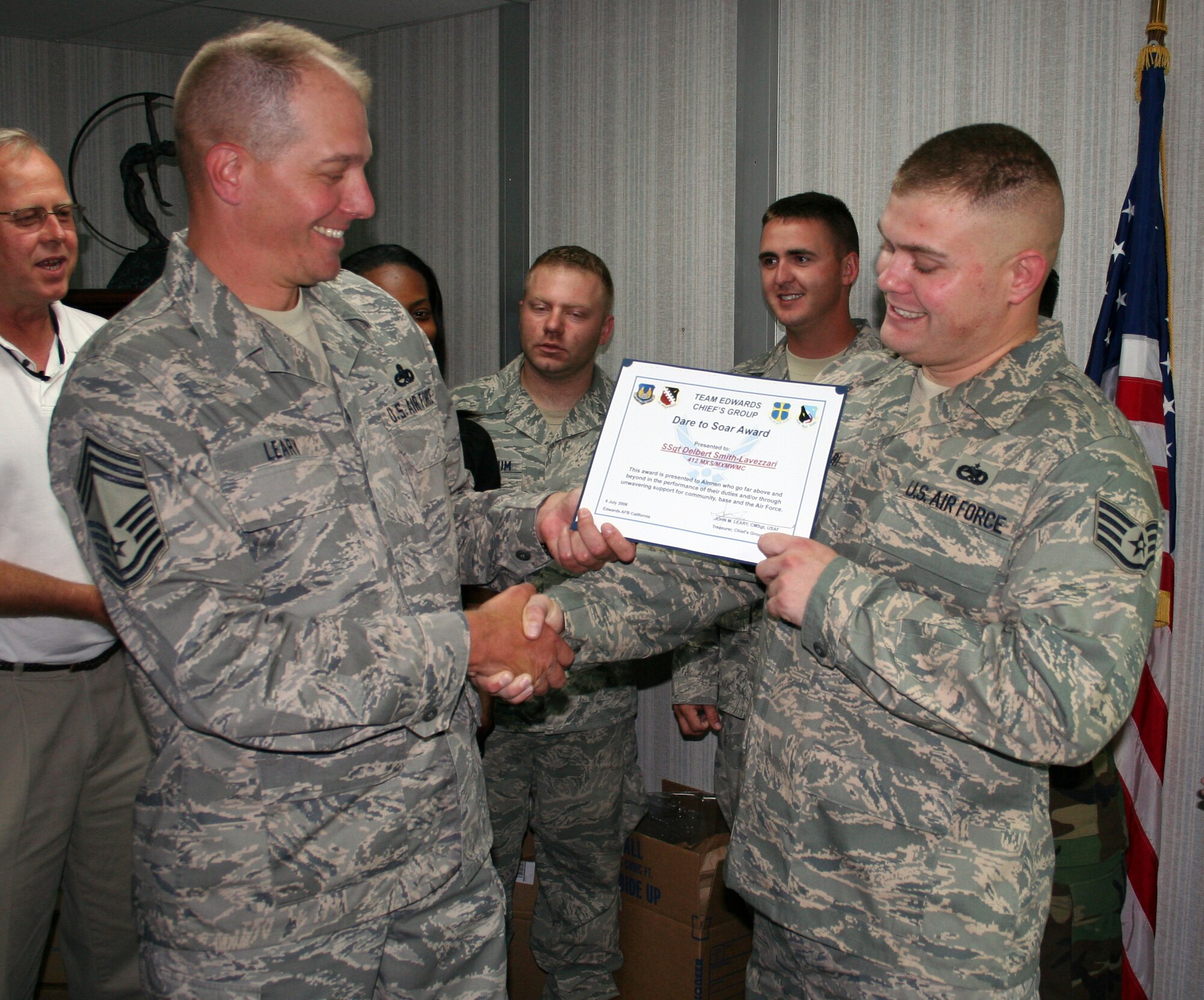 Staff Sgt. Delbert Smith-Lavezzari (right), 412th Maintenance Squadron weapons specialist, receives the Dare to Soar award July 9 from Chief Master Sgt. John Leary(left), 412th MXS superintendent. Sergeant Smith-Lavezzari received the award for his actions on Sept. 9, 2006, when he detained an armed robber at a convenience store. The award is presented by the Chiefs Group to Airmen who go above and beyond in their performance. (Air Force photo by Chief Master Sgt. Luis Drummond)